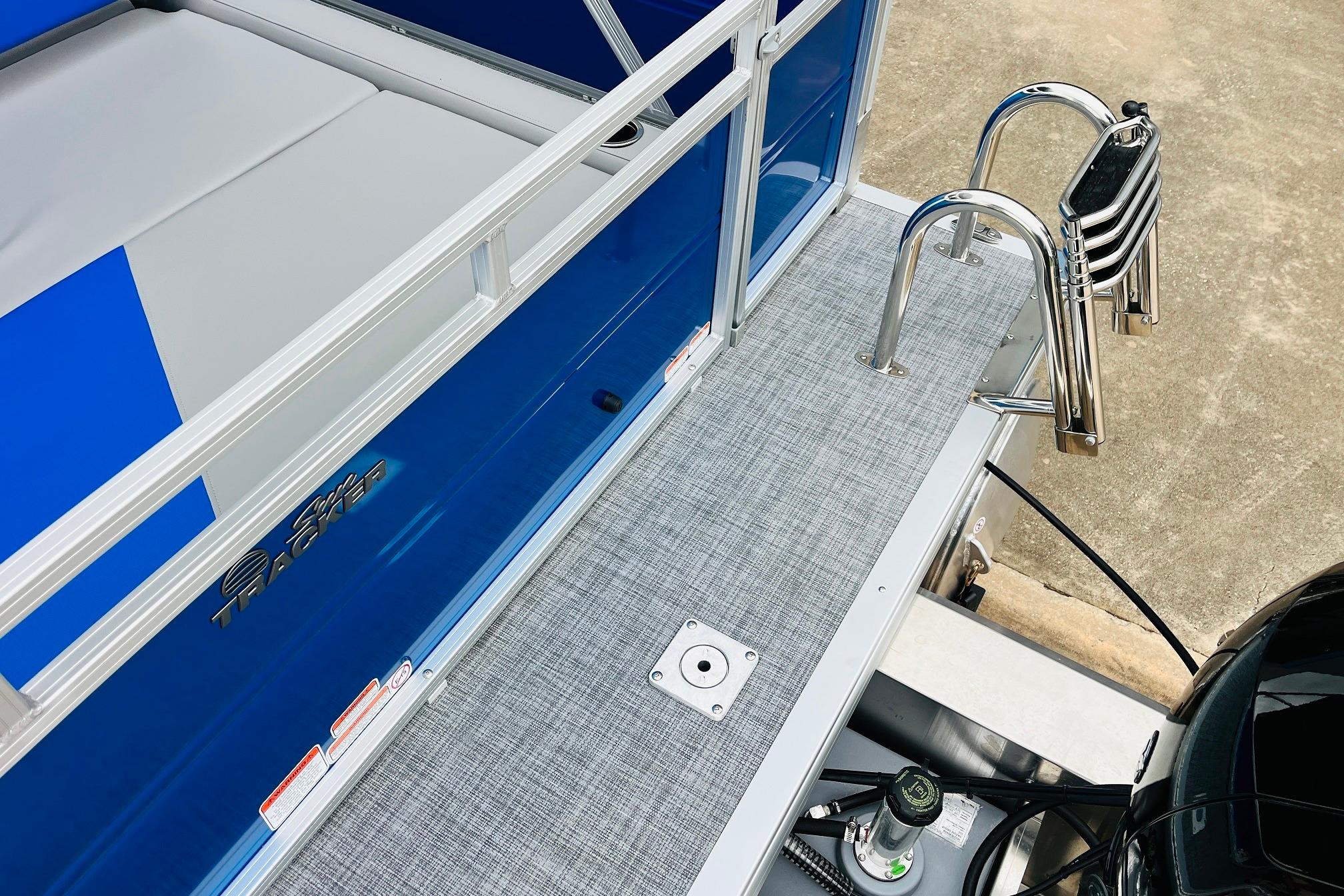 2026 Sun Tracker Party Barge 22 RF DLX pontoon boat with blue exterior and stainless steel ladder.