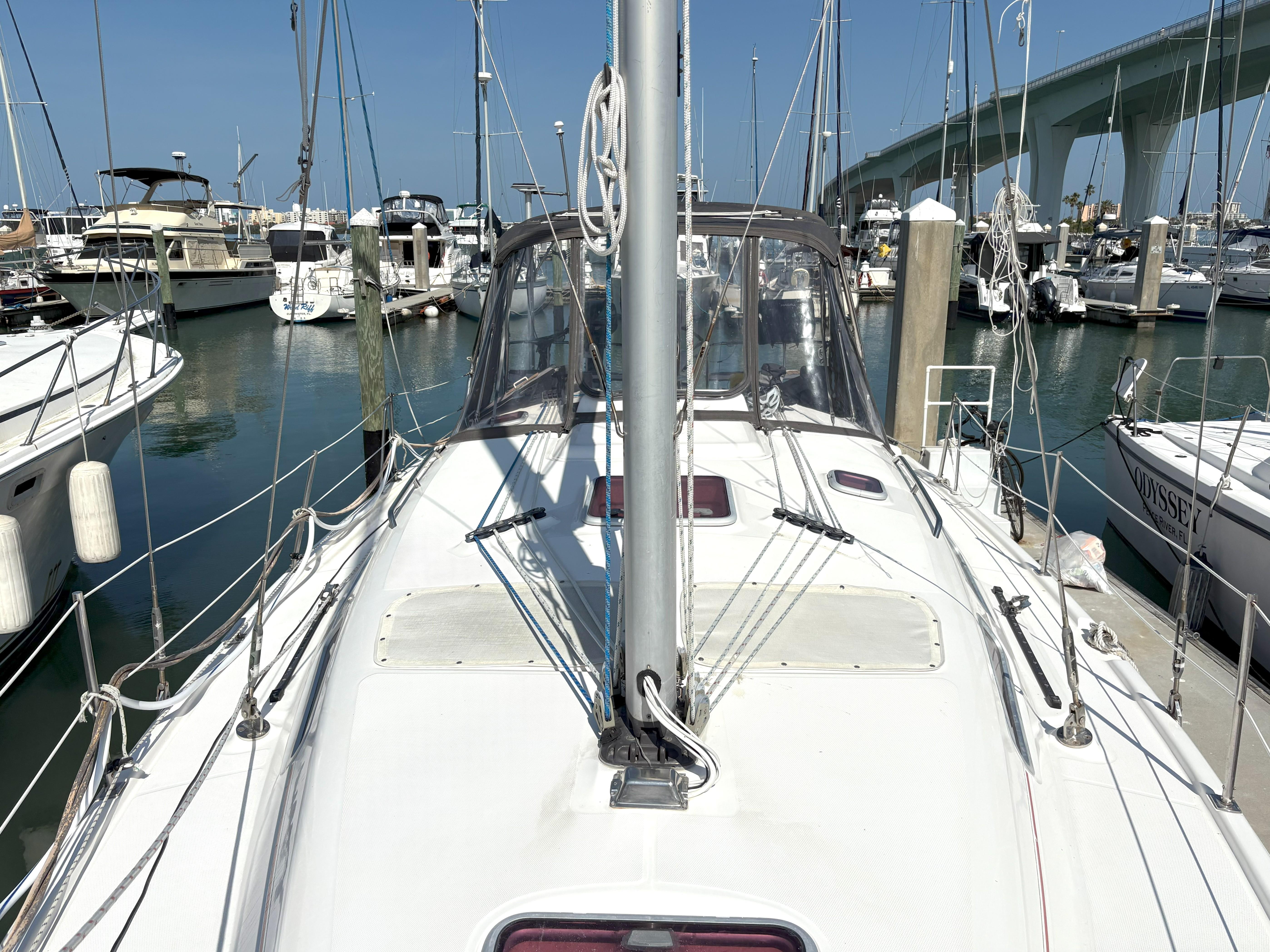 Sailboat Hunter 38, 2005 model, docked in marina with bridge in background.