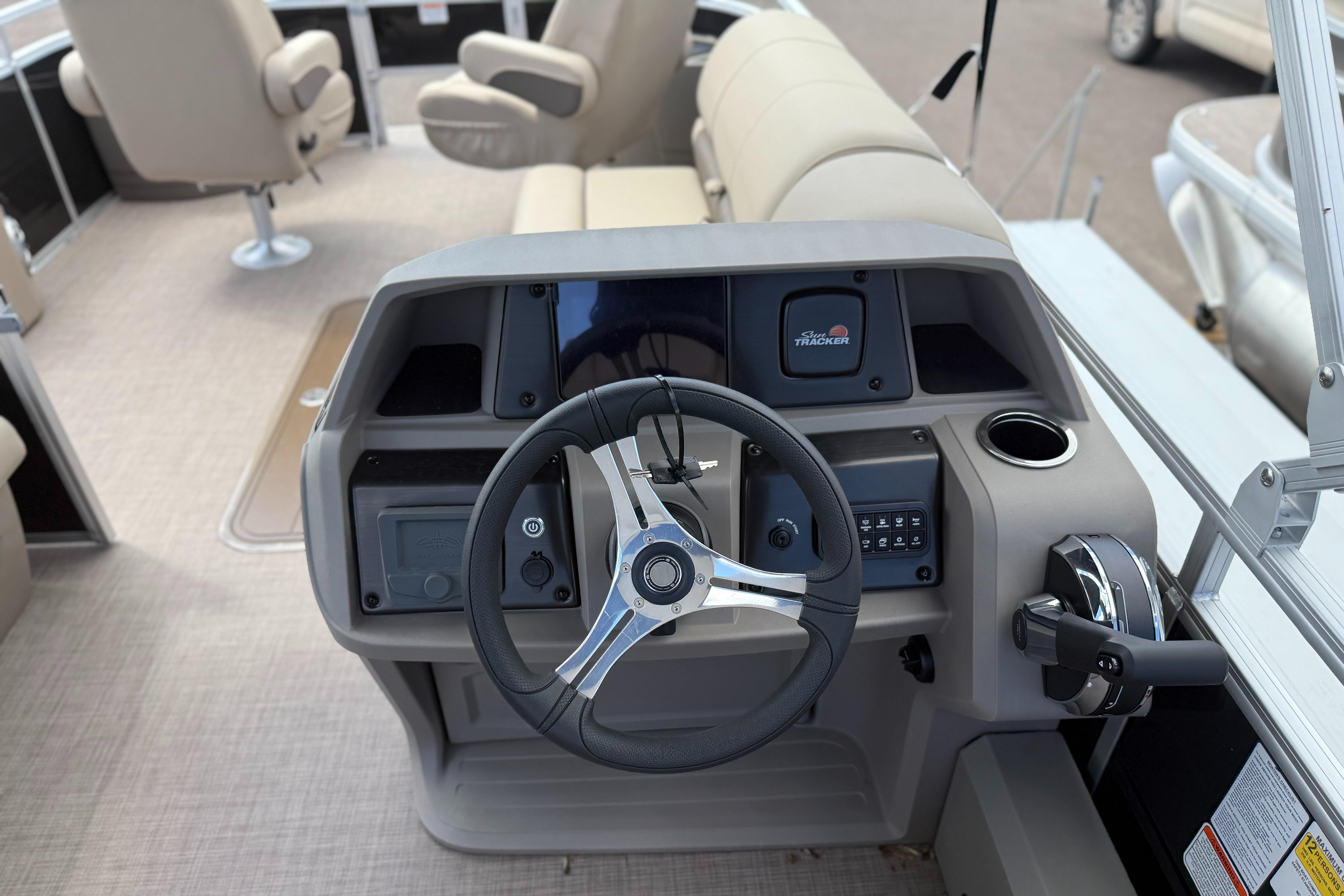 2024 Sun Tracker Sportfish 24 XP3 boat dashboard with steering wheel and controls.