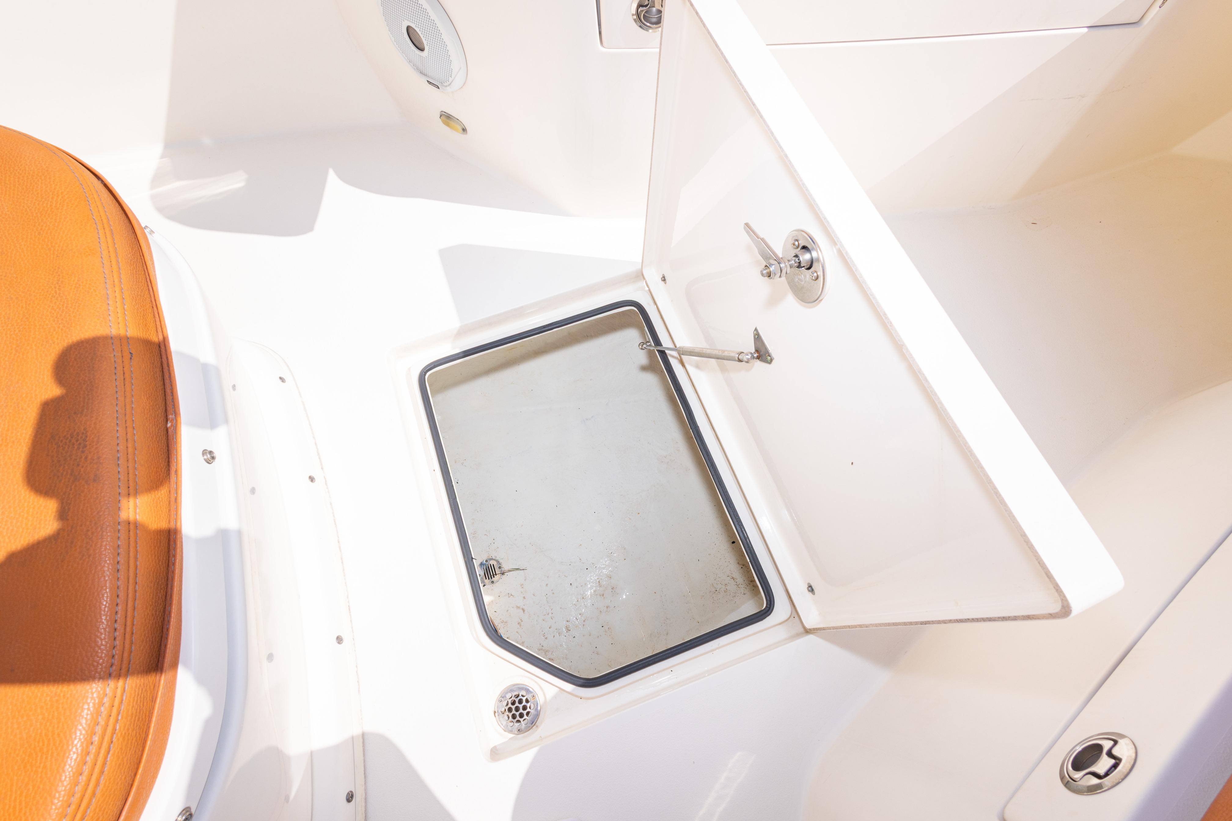2017 Cobia 261 Center Console boat storage compartment with open hatch and seating.