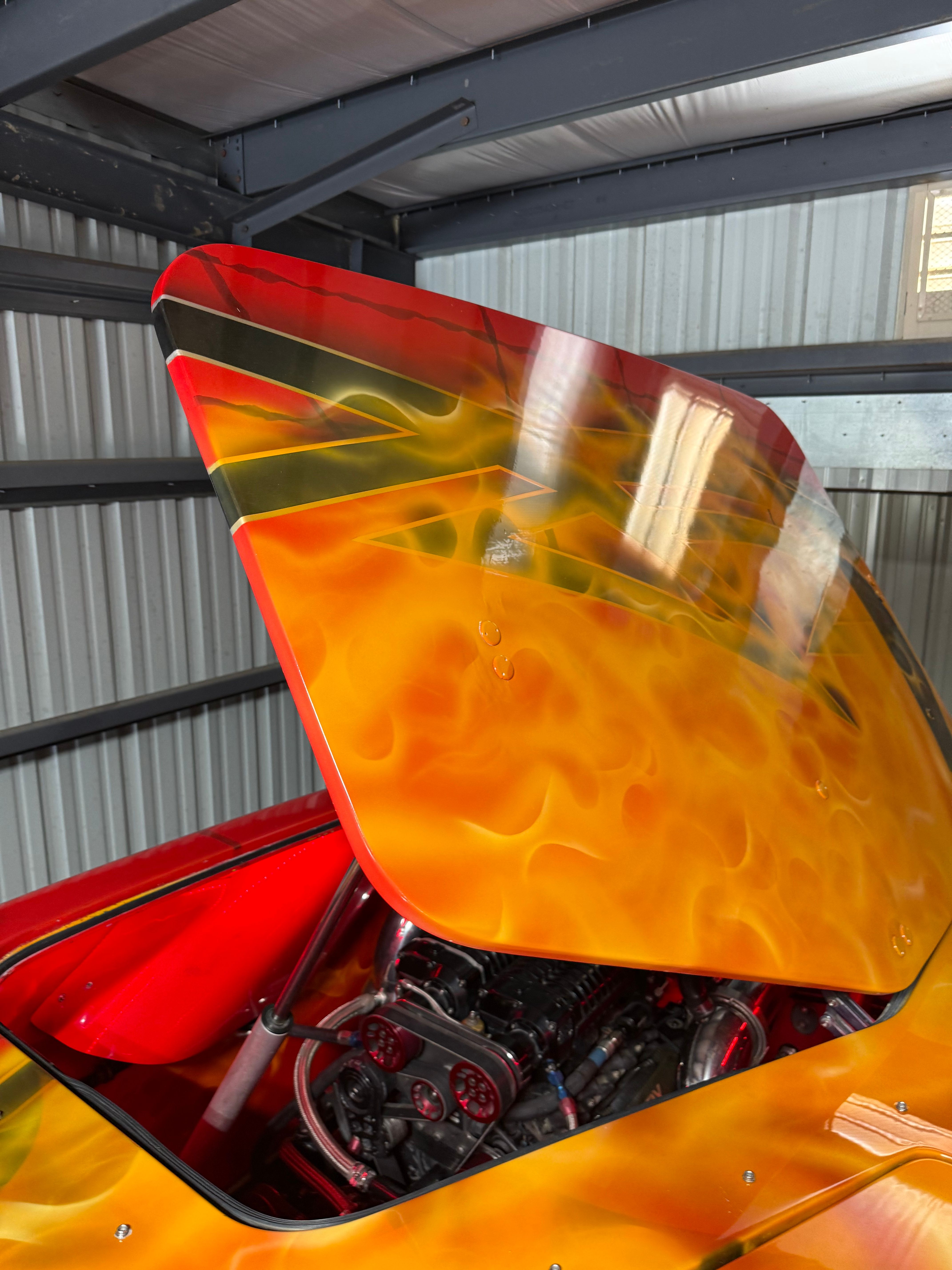 A 2010 MTI CAT with a striking flame-like paint job. The engine compartment is partially visible.