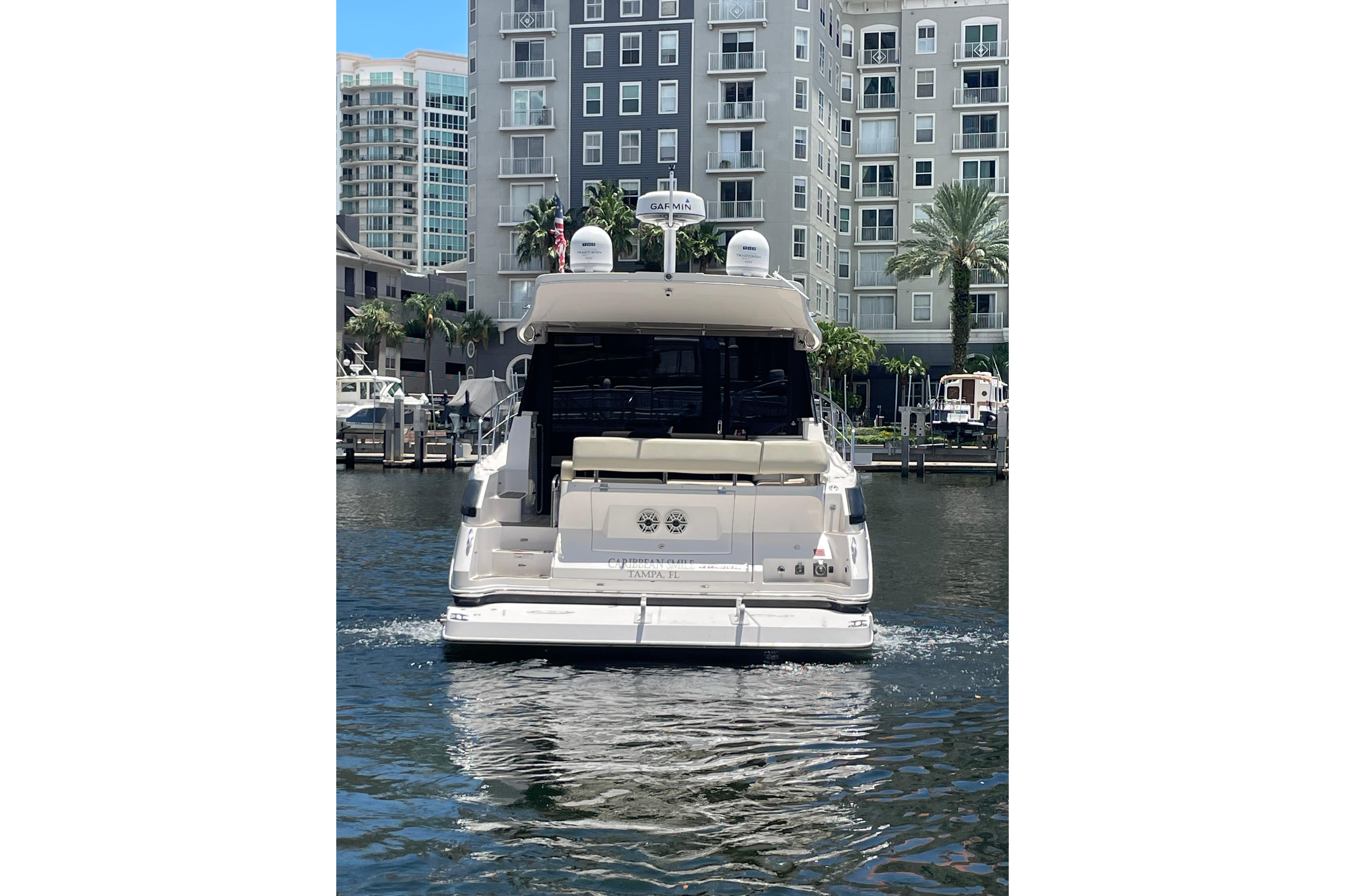 2020 Regal 42 Grande Coupe yacht docked near waterfront buildings.