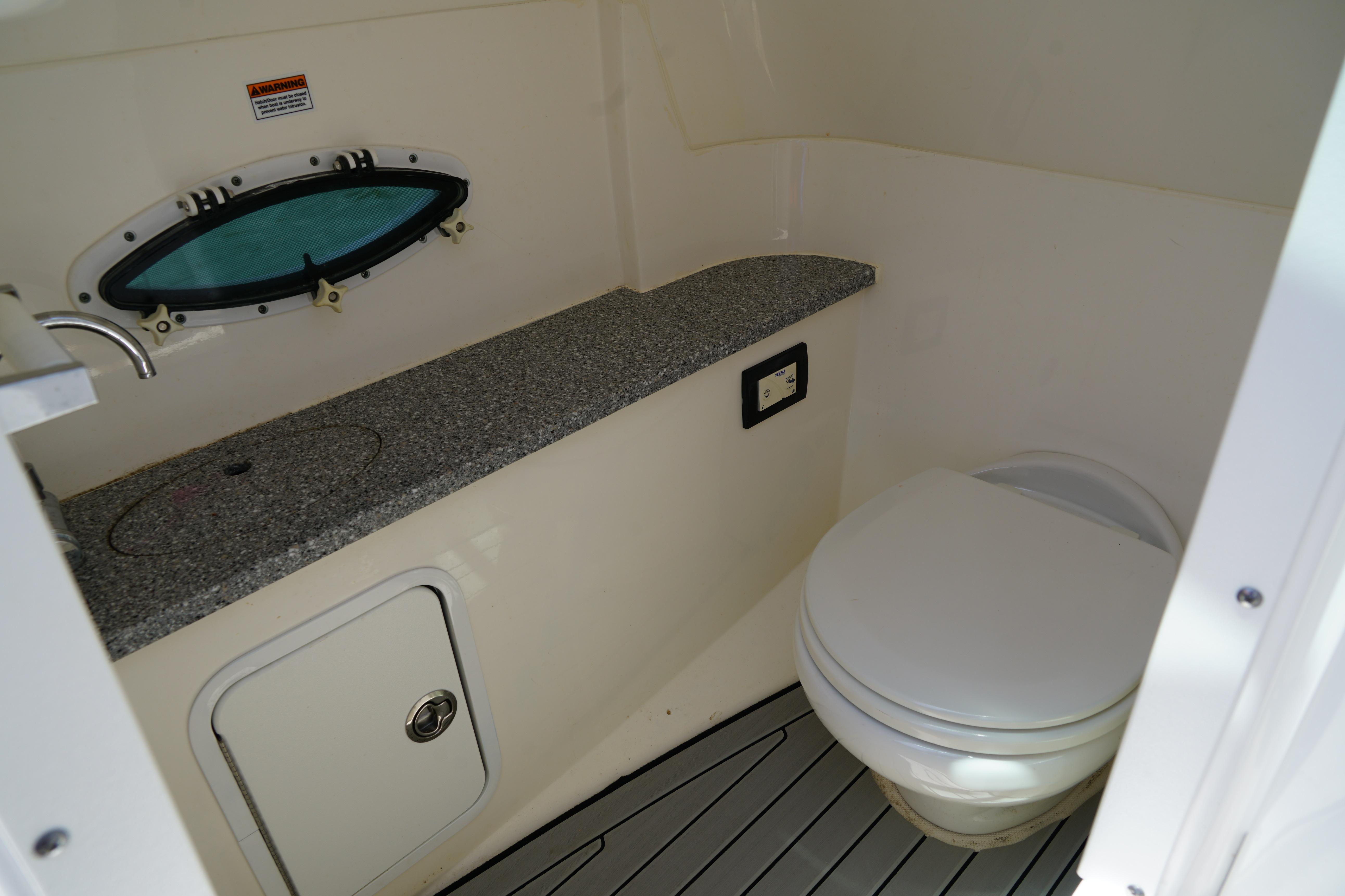 2020 Hurricane SunDeck 2486 OB boat bathroom with sink and toilet.