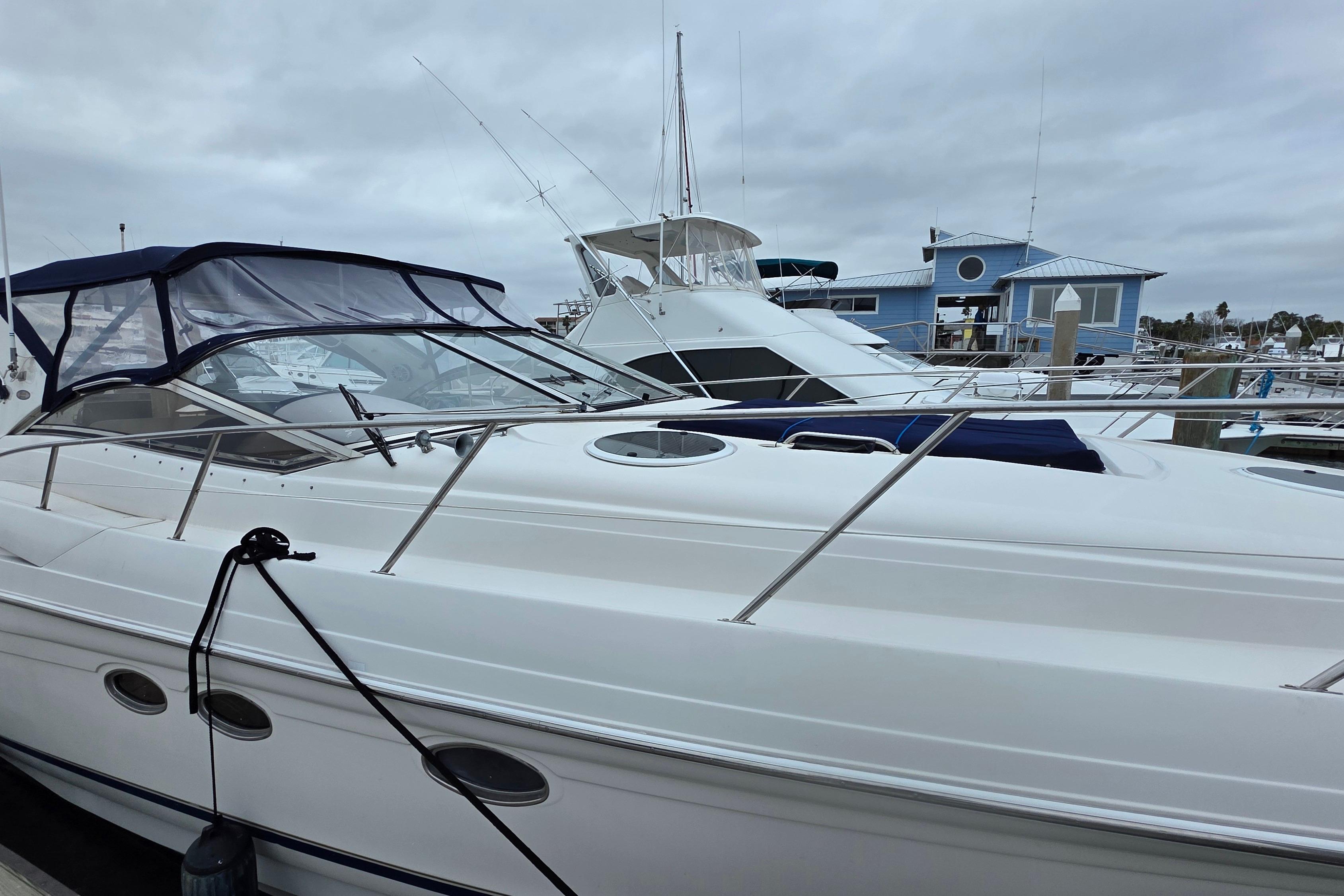 2002 Regal Commodore 4260 yacht docked at marina under cloudy skies.