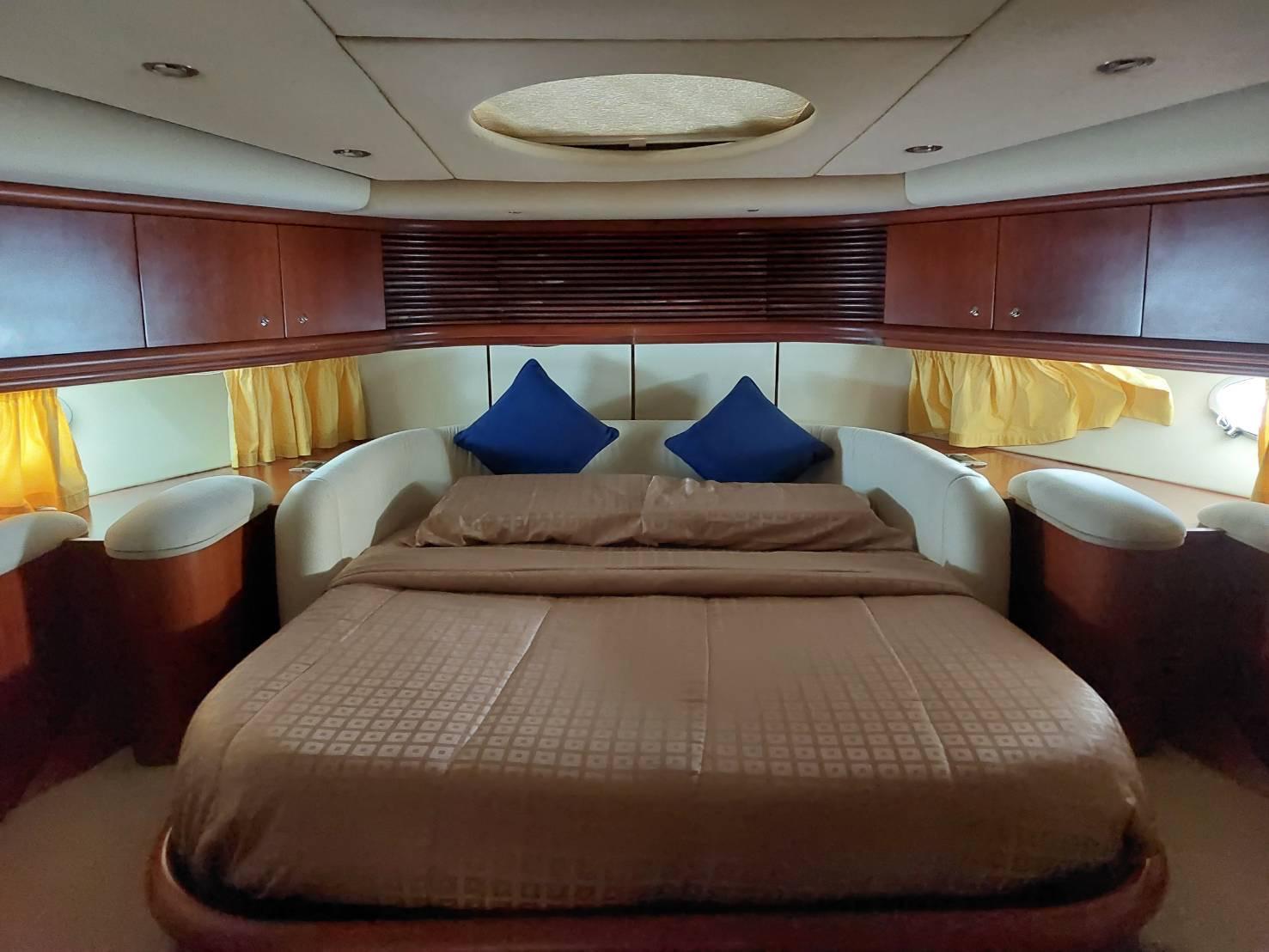 Luxurious bedroom interior of 2000 Sunseeker Predator 80 yacht with elegant wood finish.
