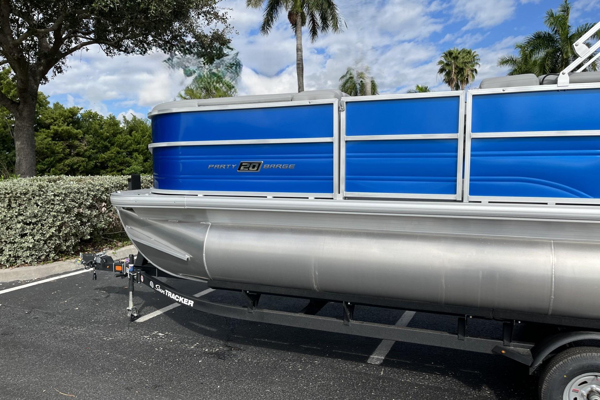 2026 Sun Tracker Party Barge 20 DLX pontoon boat on trailer, parked outdoors.
