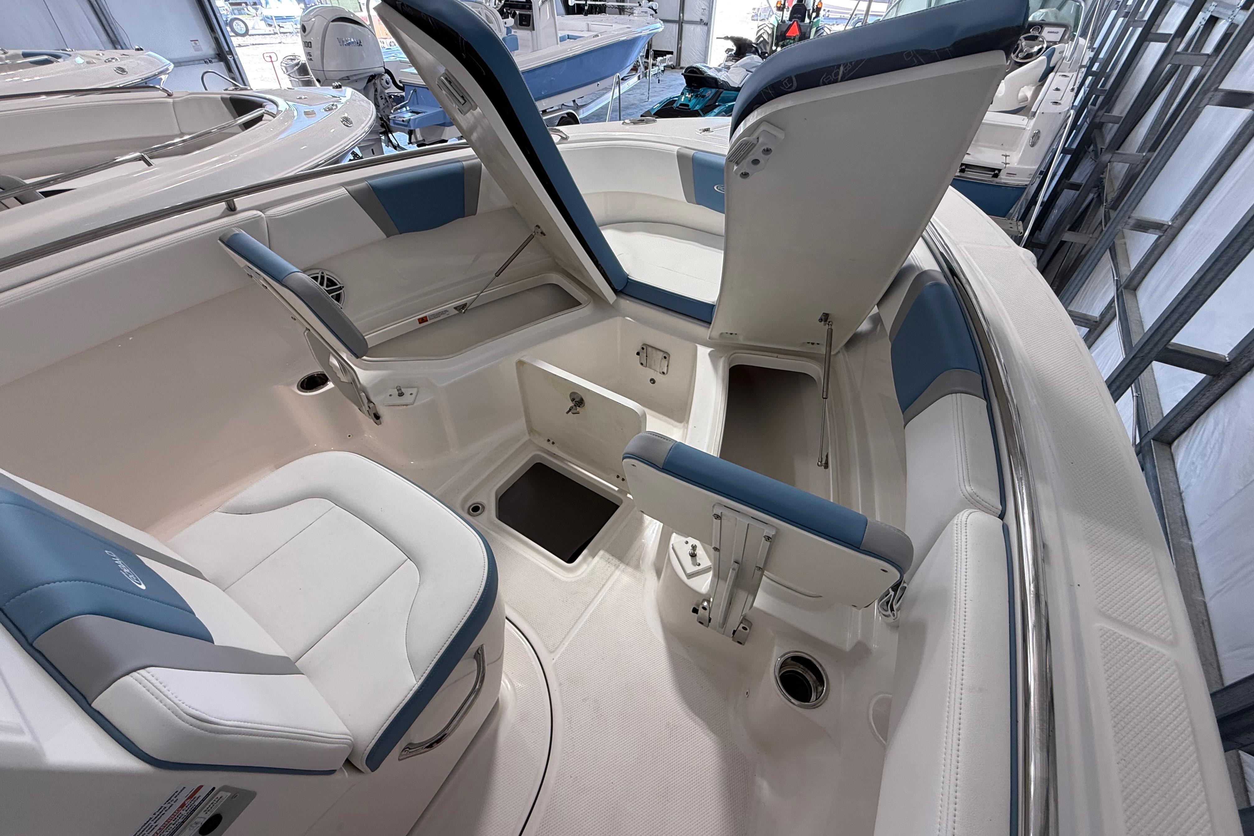 2026 Robalo 246 Cayman boat interior with open storage compartments and cushioned seating.