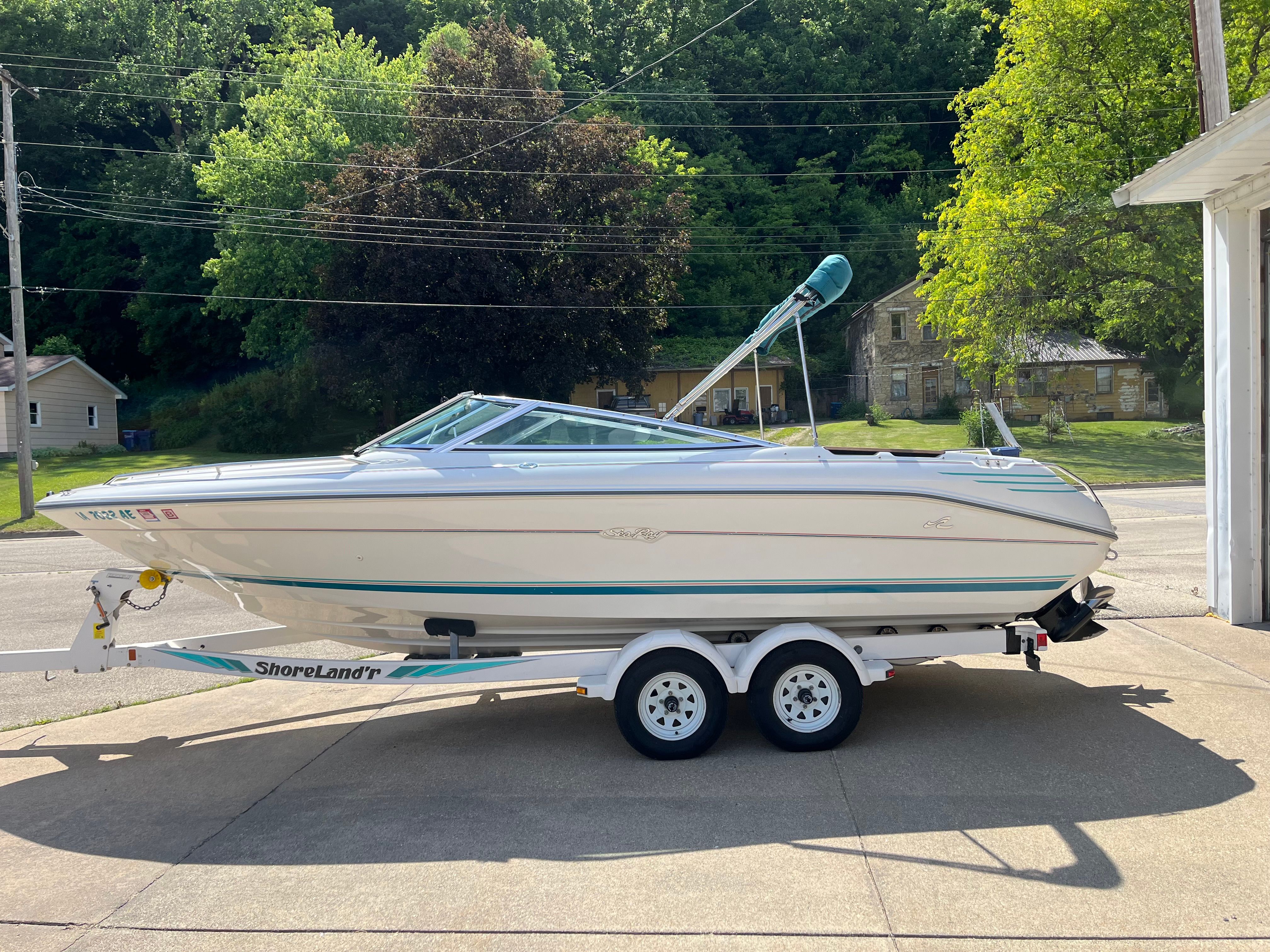 A 1992 Sea Ray 220 Bow Rider on a trailer, parked on a driveway.