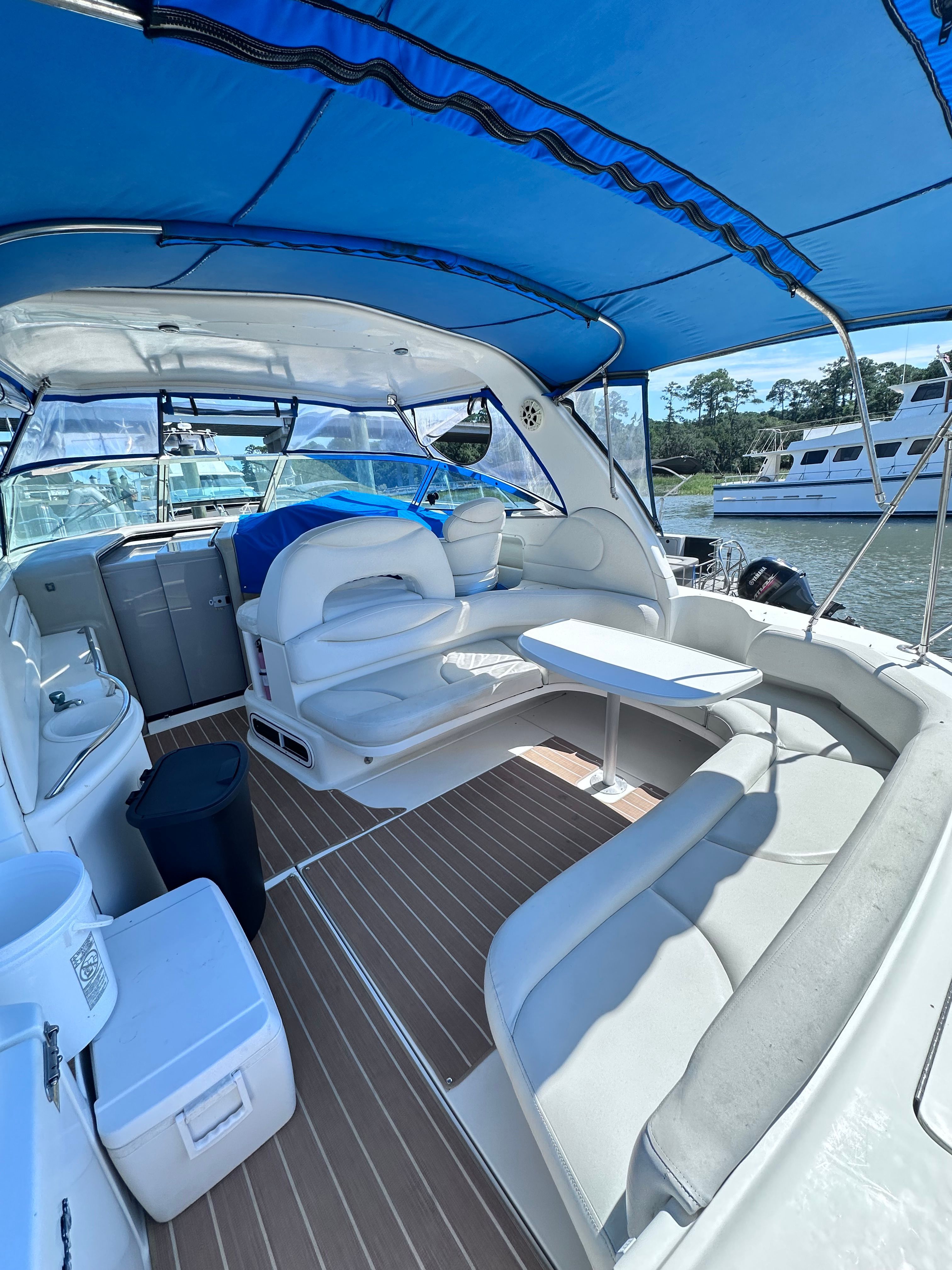 Interior of 2000 Sea Ray 380 Sundancer yacht with blue canopy and white seating.