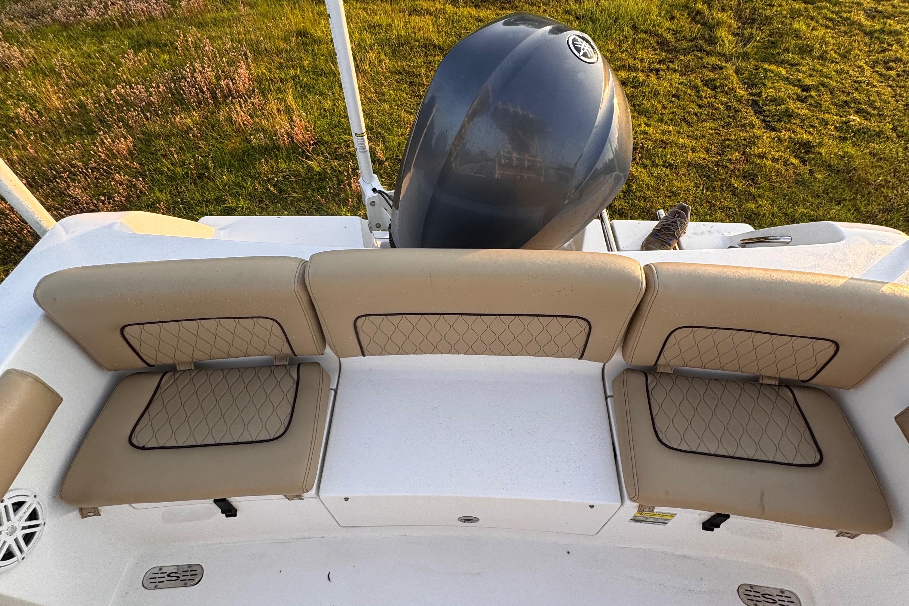 2019 Sportsman 231 Heritage Platinum boat with cushioned seating and outboard motor.