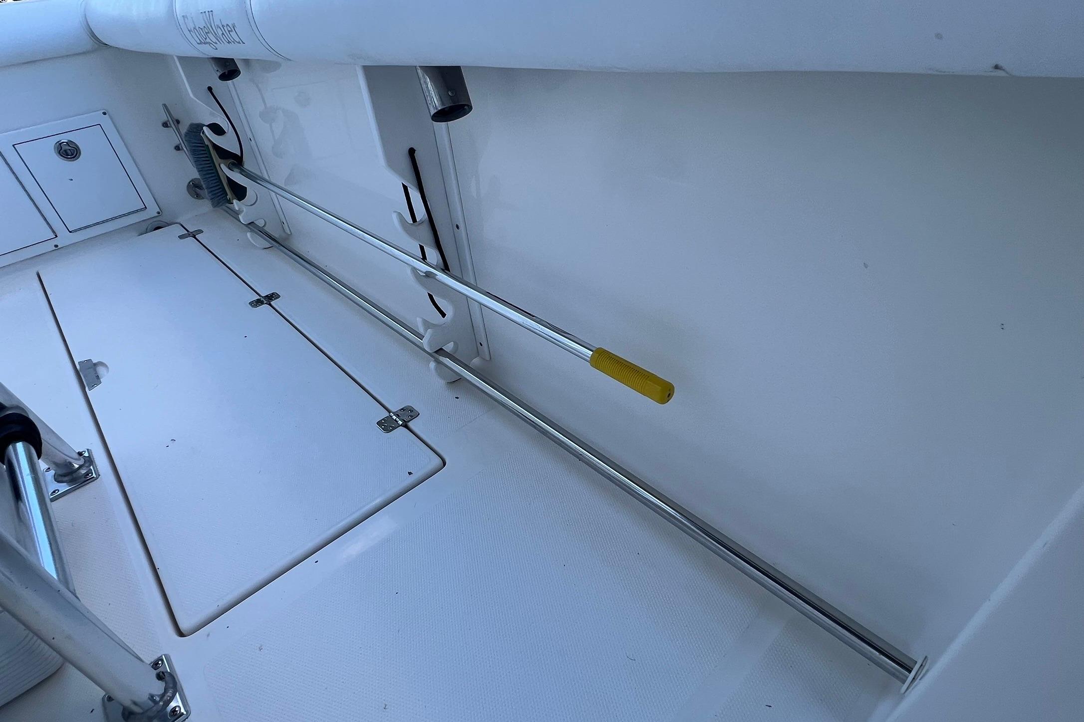 Interior view of a 2006 Edgewater 245CC boat, featuring storage compartments and rod holders.