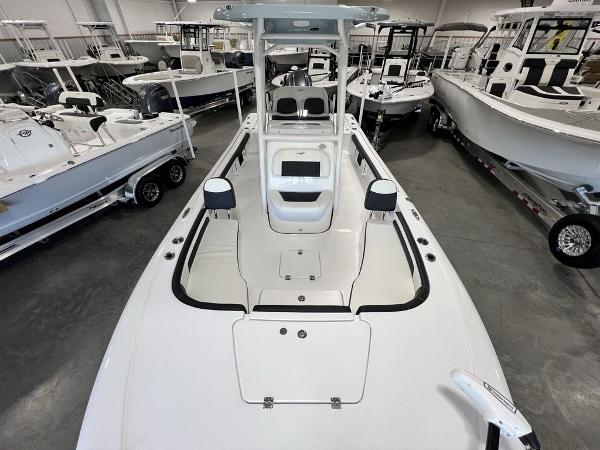 2025 Tidewater 2300 Carolina Bay boat in showroom, surrounded by other boats.