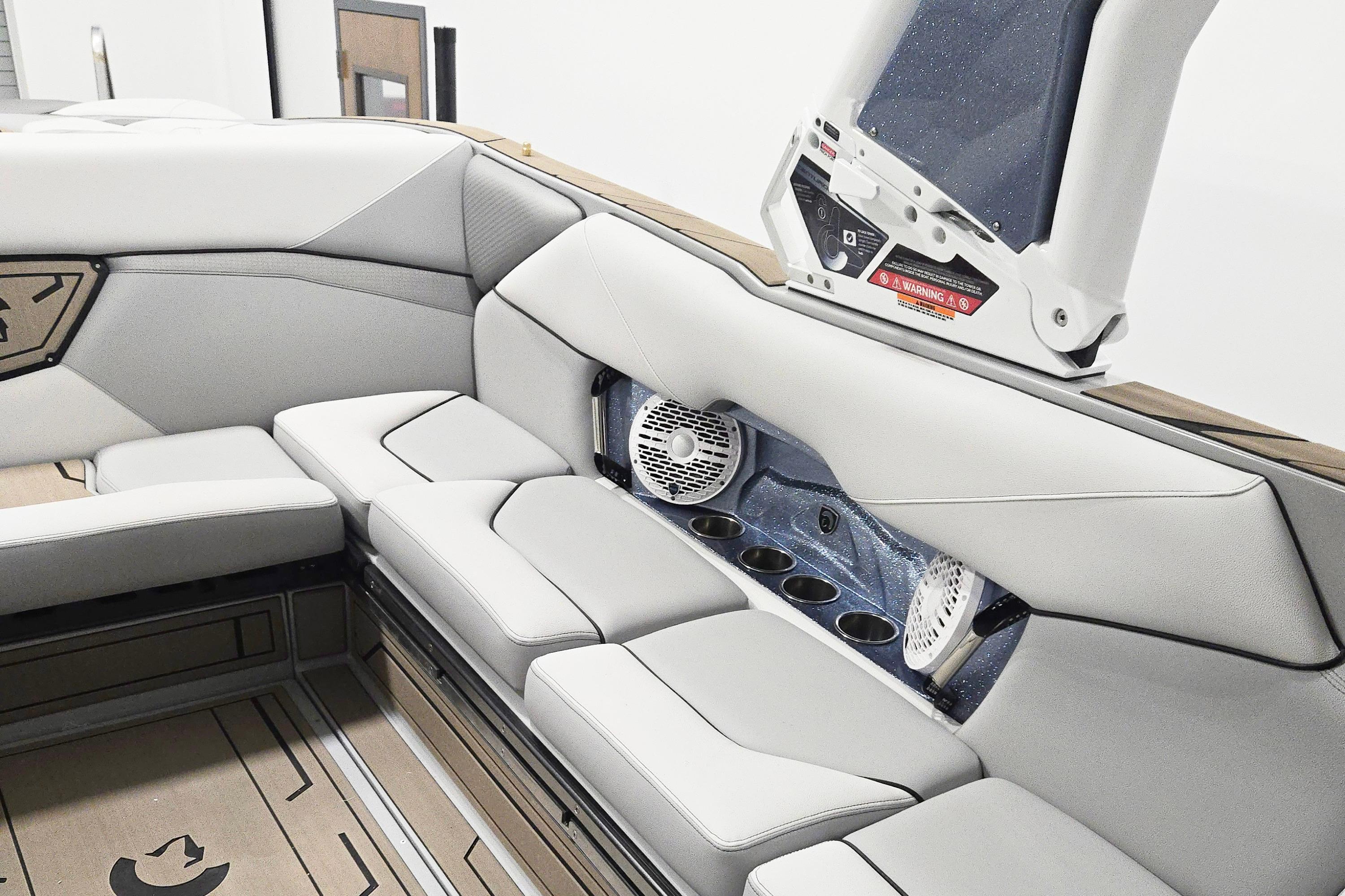 Luxurious interior of 2026 Centurion Nv243 boat with plush seating and built-in speakers.