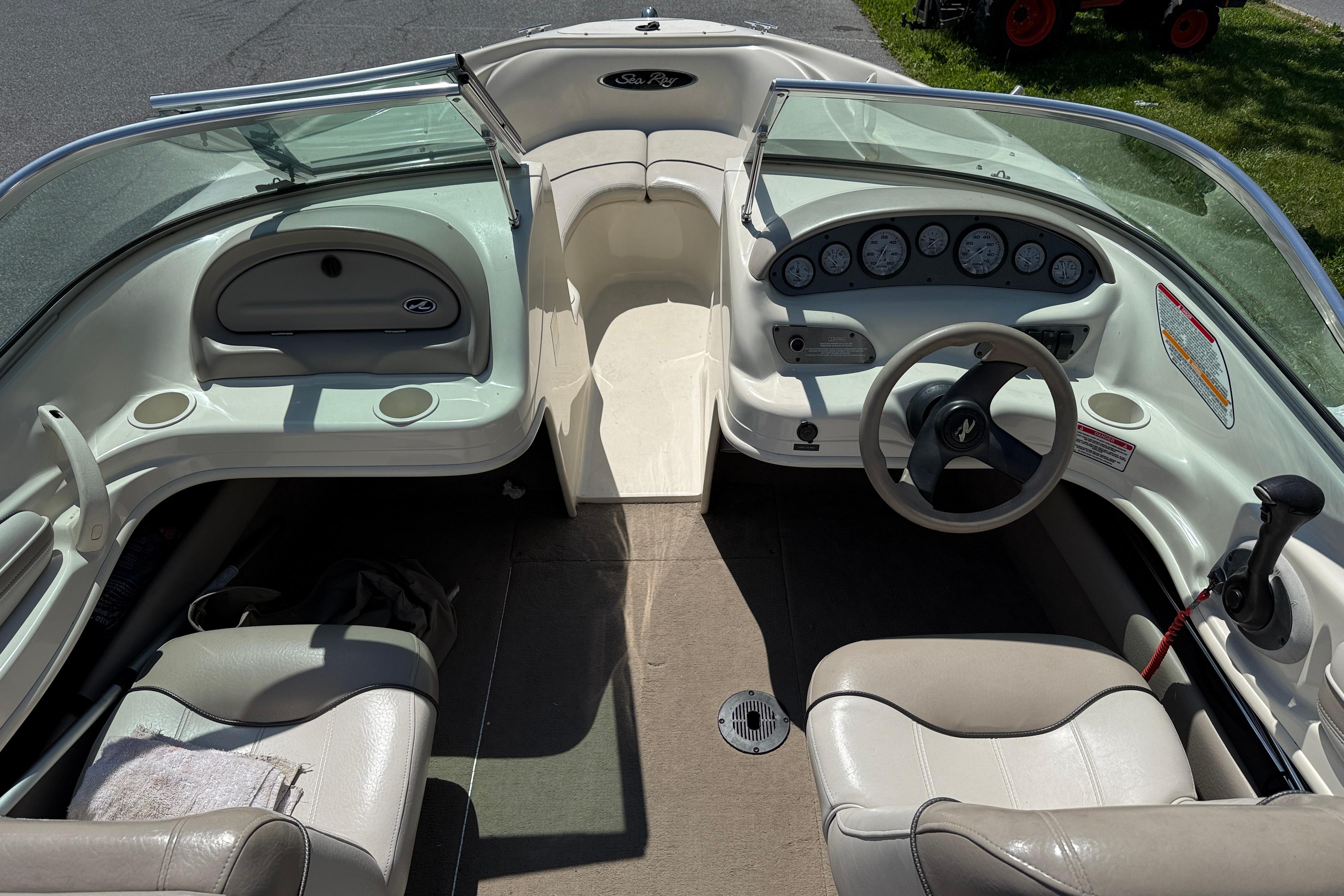 2003 Sea Ray 182 Bow Rider interior with steering wheel, dashboard, and seating.
