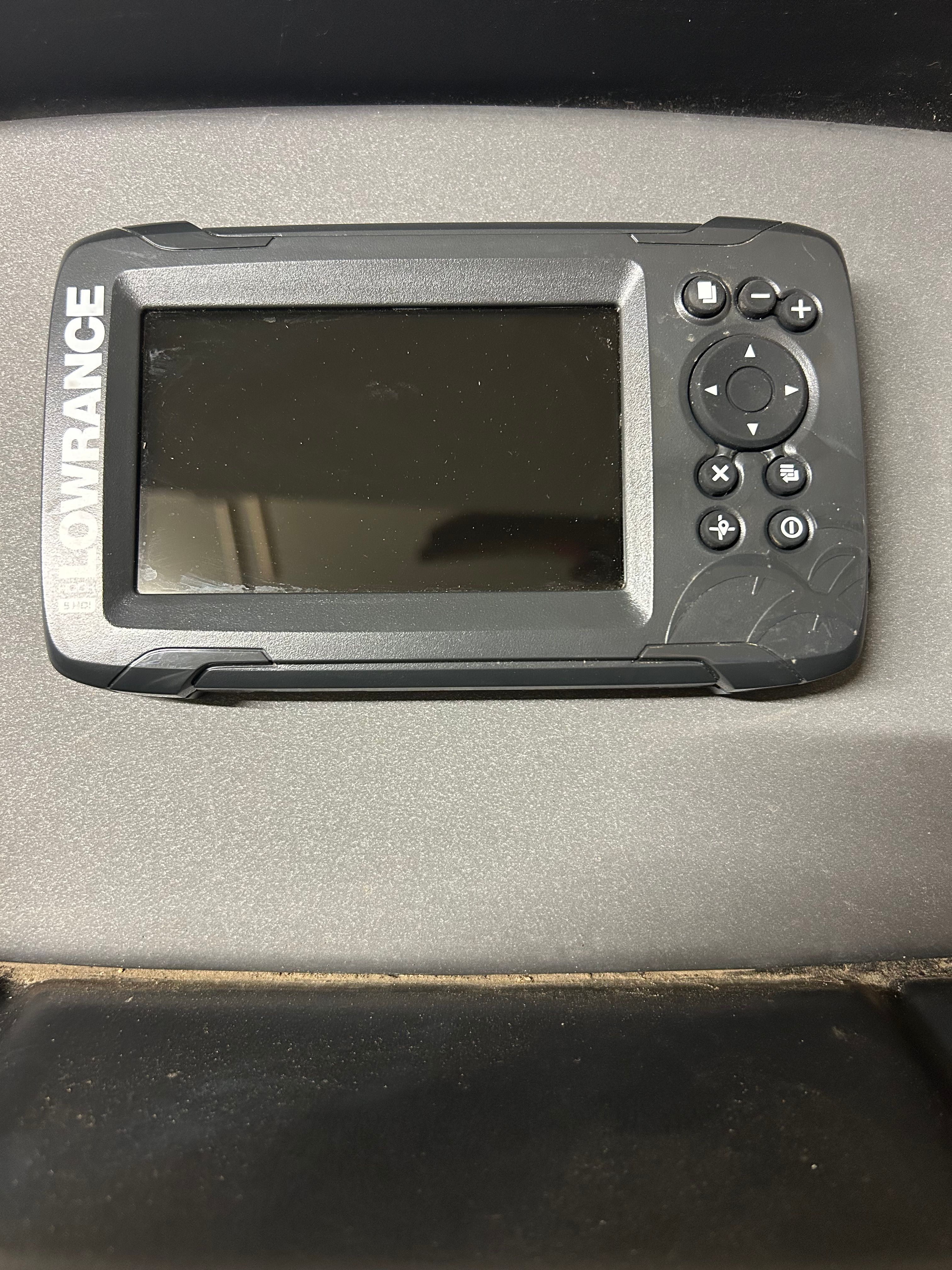 A Lowrance fish finder is mounted on a boat's dashboard.