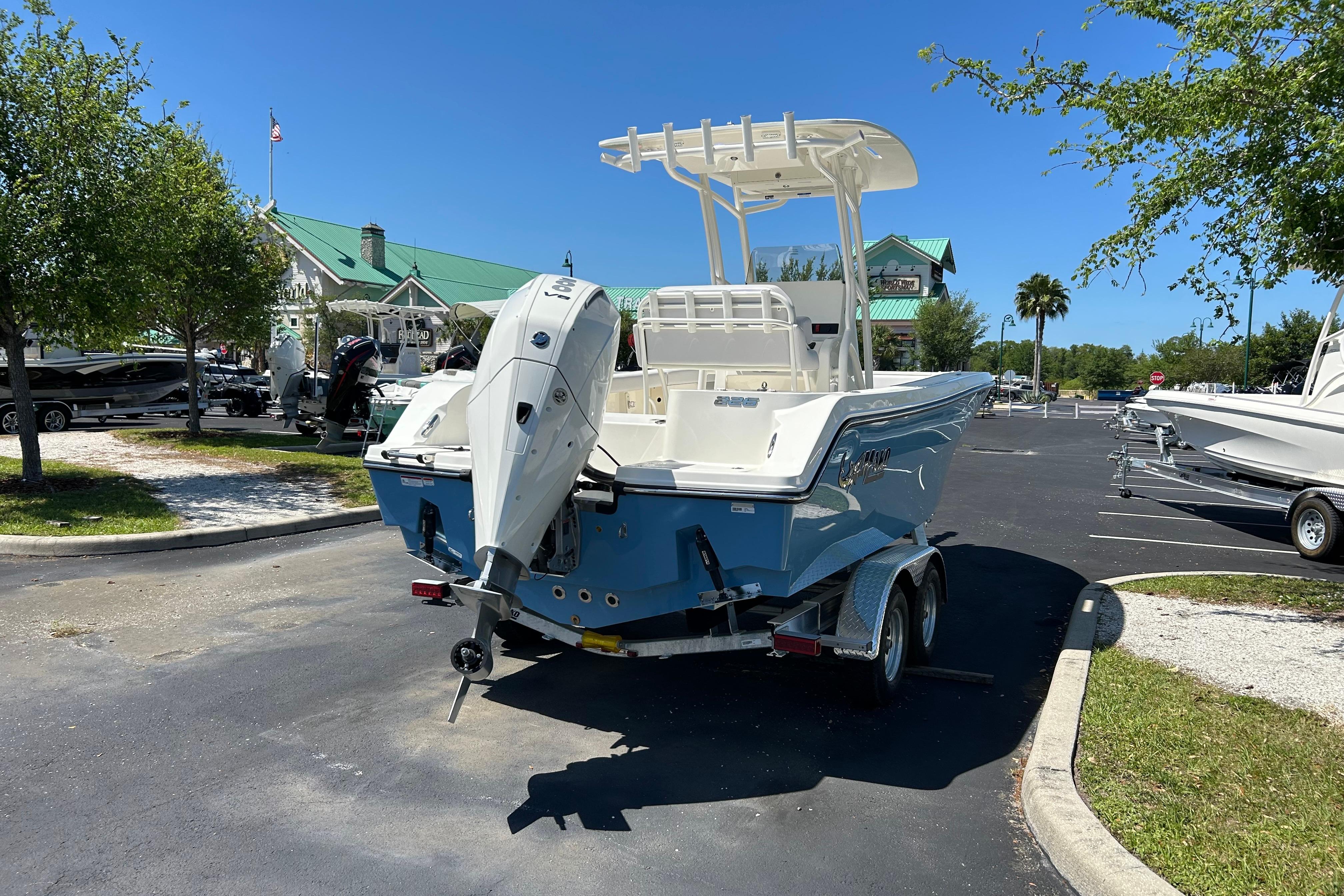 2026 Mako 226 Center Console boat on trailer in sunny parking lot.