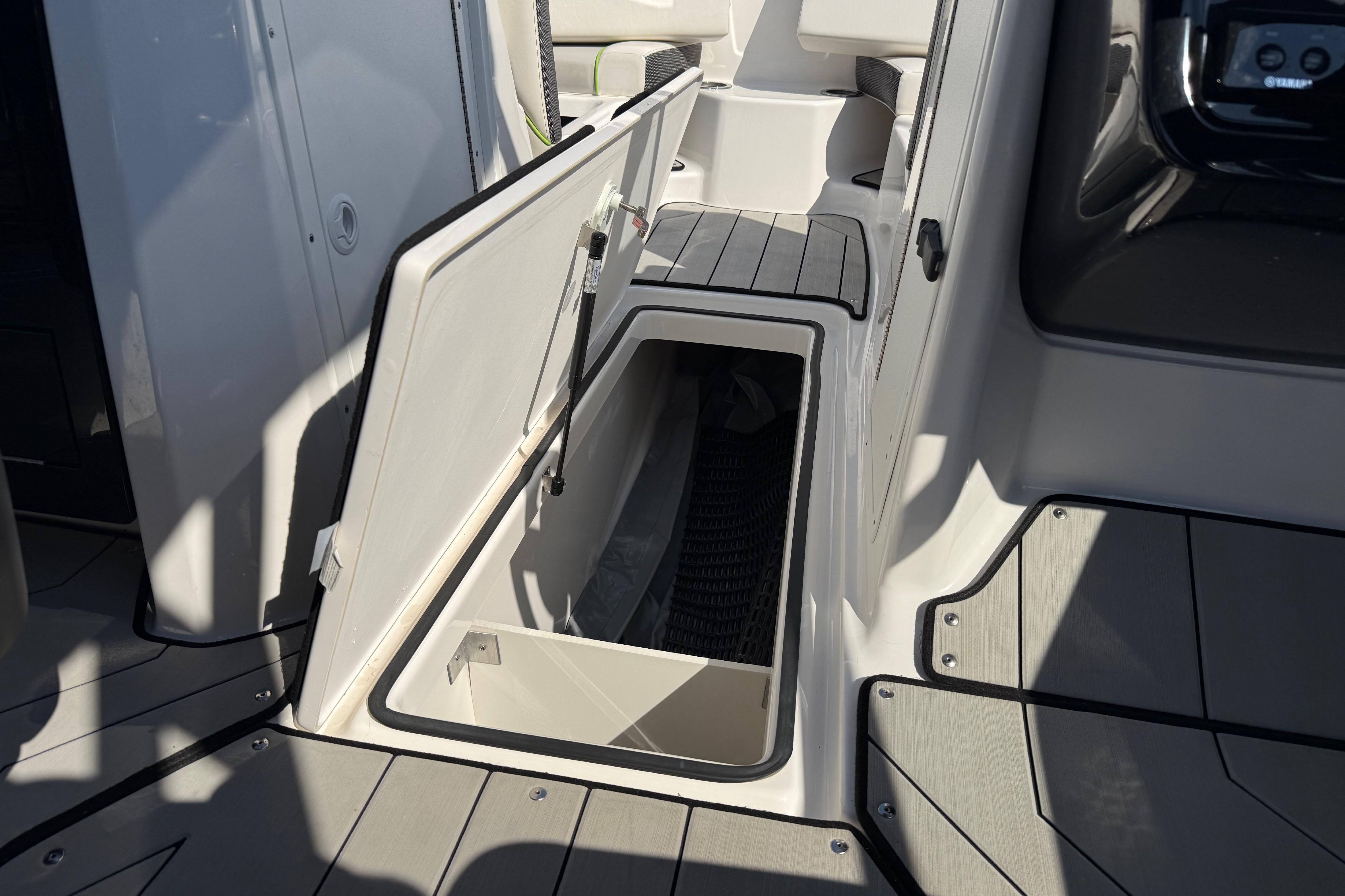 2022 Yamaha Boats 212XE interior storage compartment with open hatch, showcasing sleek design.