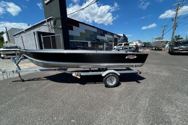 2027 Lund WC 16 boat on trailer, parked outdoors under a clear blue sky.