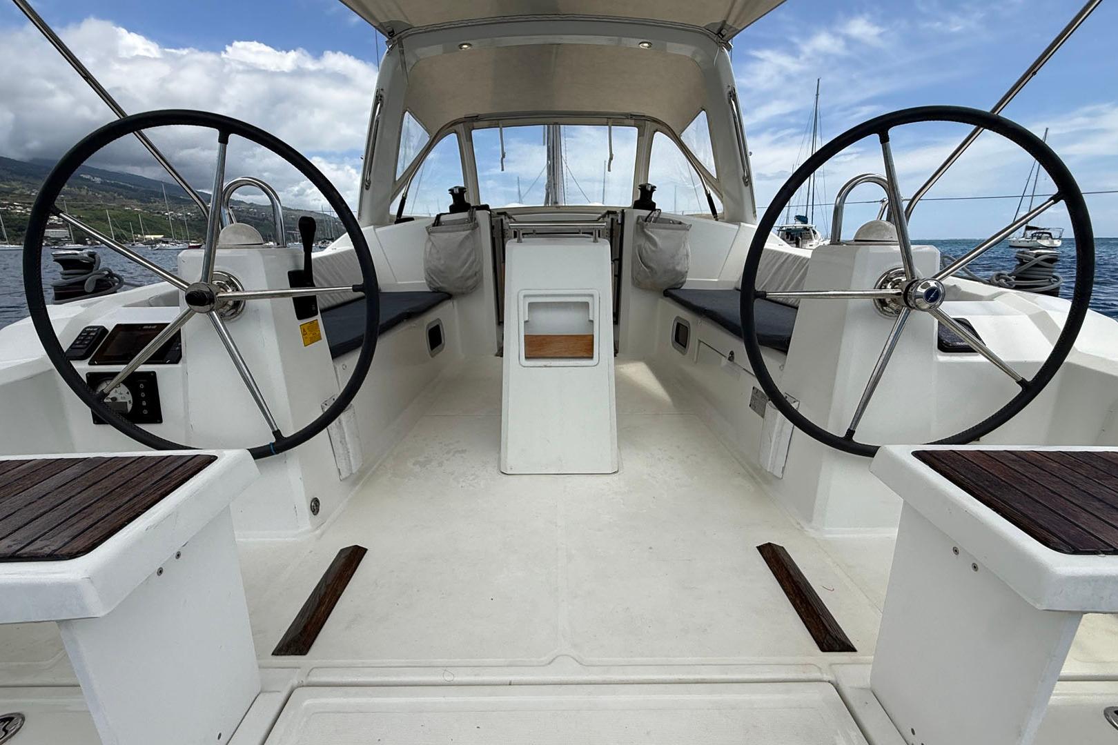 2016 Beneteau Oceanis 38 yacht cockpit with dual steering wheels, open sea view.