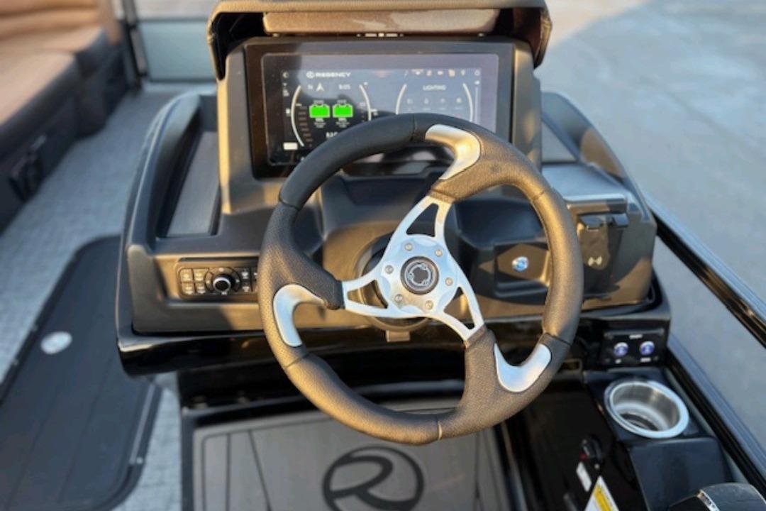 Steering console of 2026 Regency 230 DL boat with digital display and controls.