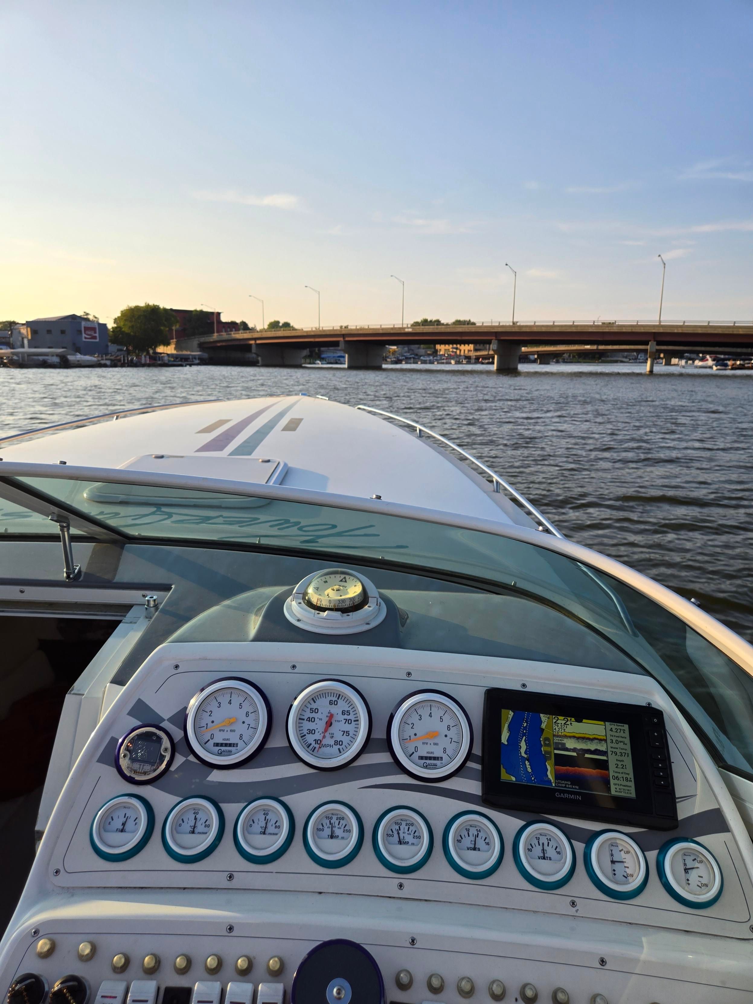 The dashboard of a 1998 Powerquest Enticer 290 FX with a view of a bridge.