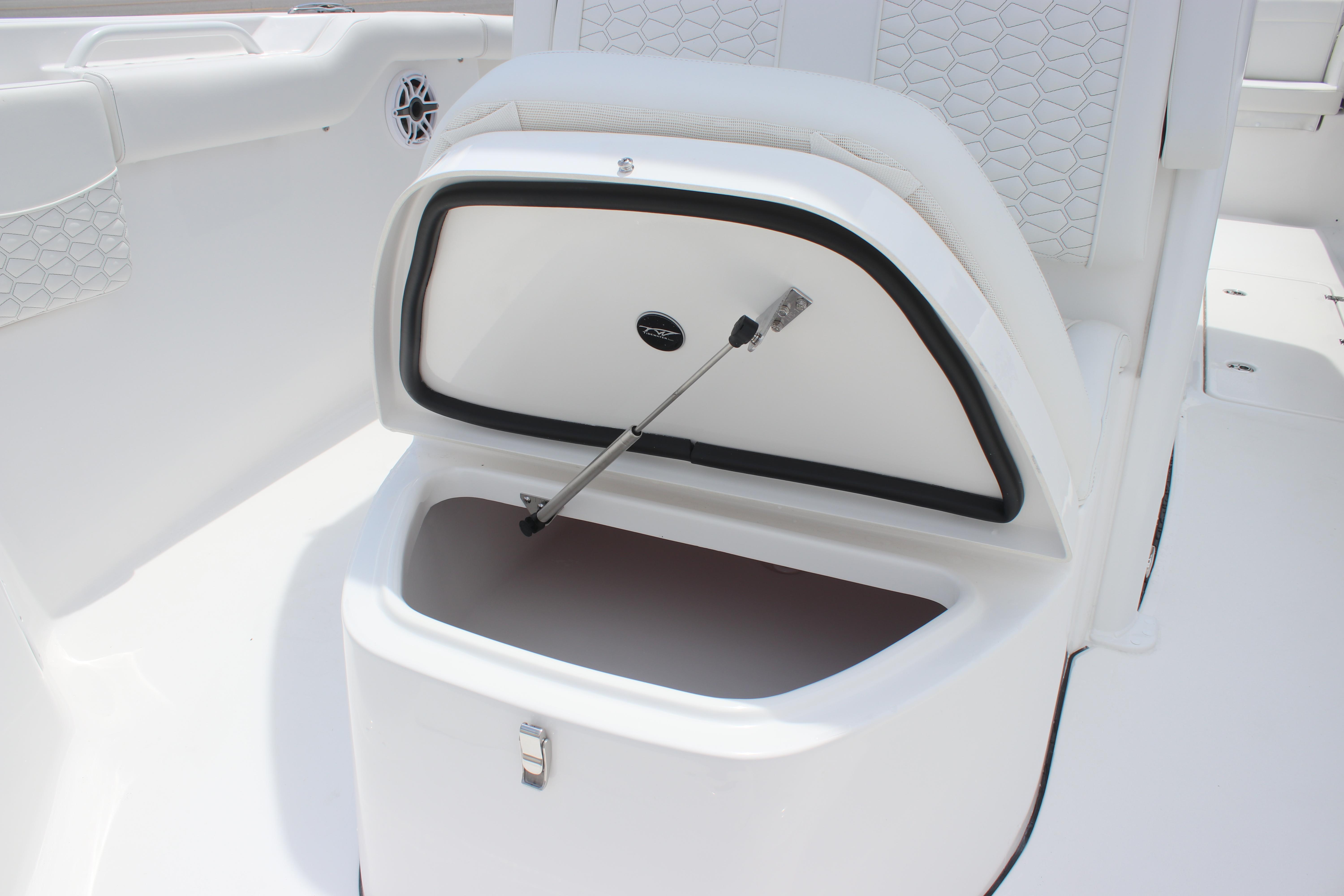 Open storage compartment on 2026 Tidewater 272 LXF boat, featuring sleek white interior design.