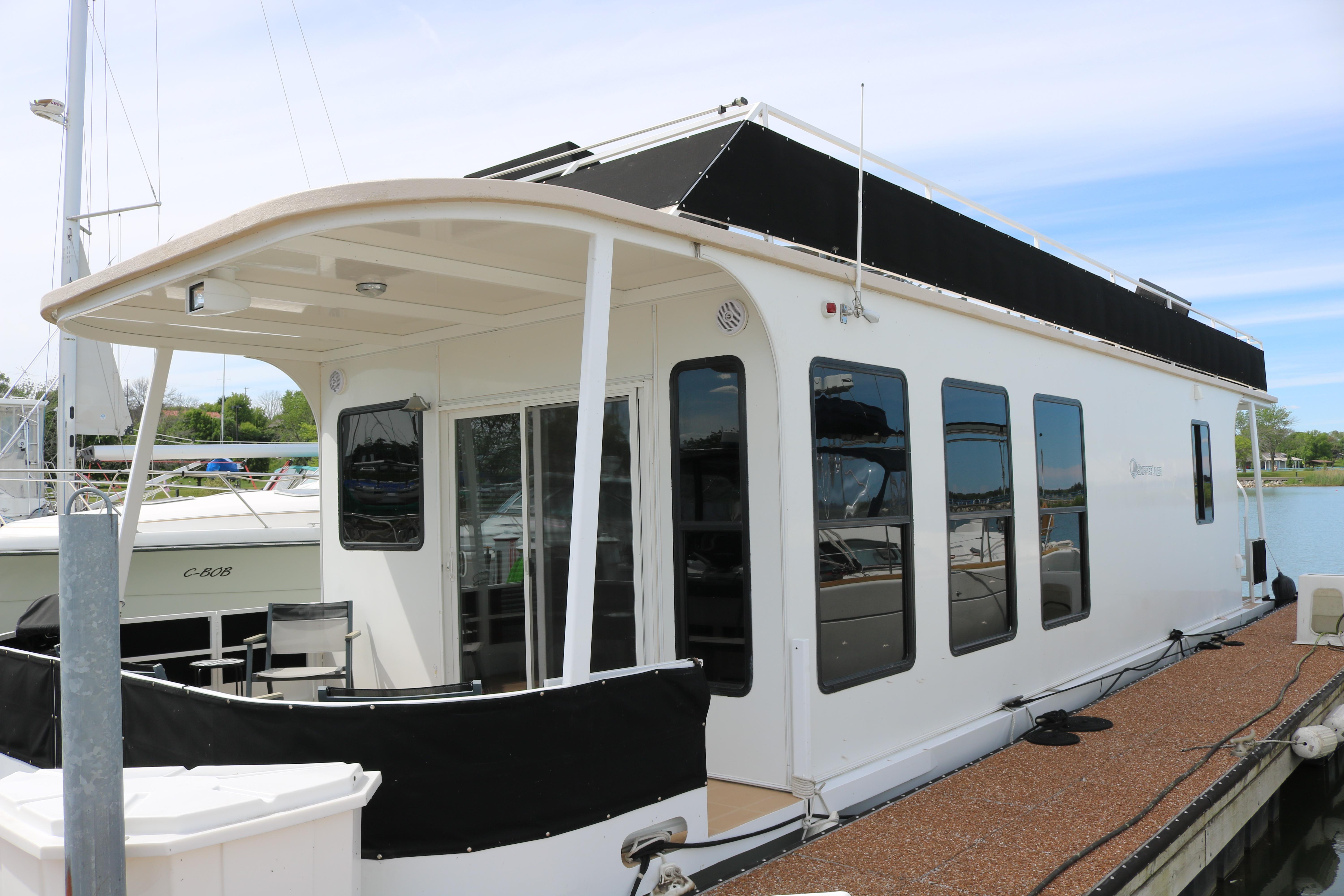 2010 Skipperliner 480 Flybridge docked, featuring sleek design and spacious deck area.