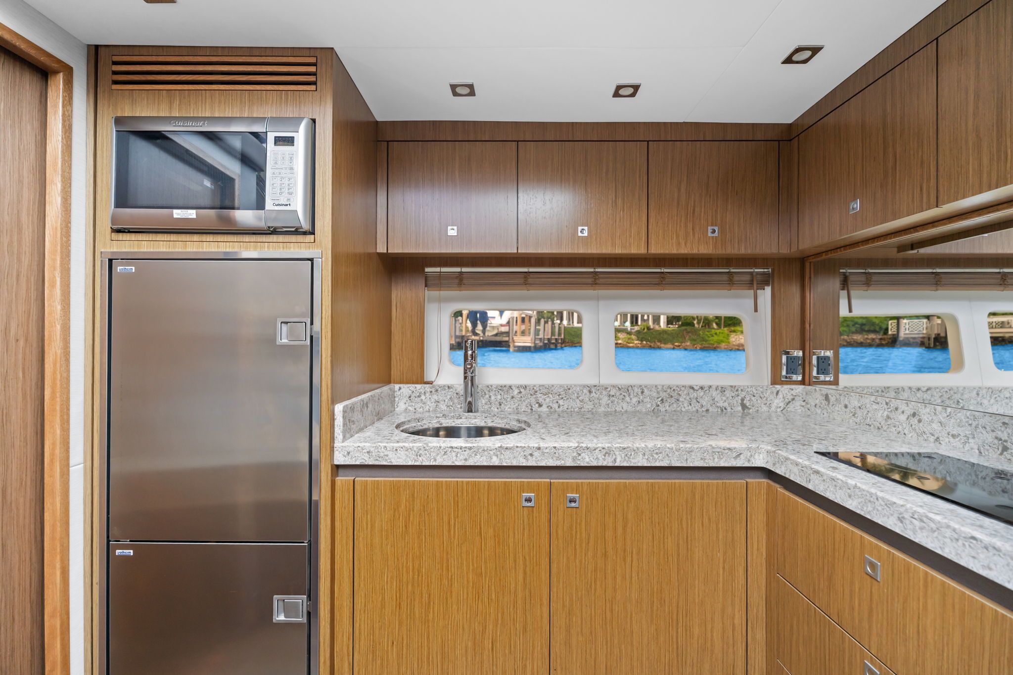 The 2017 Sea Ray Sundancer 510 kitchen features modern wood cabinets and stainless steel appliances.