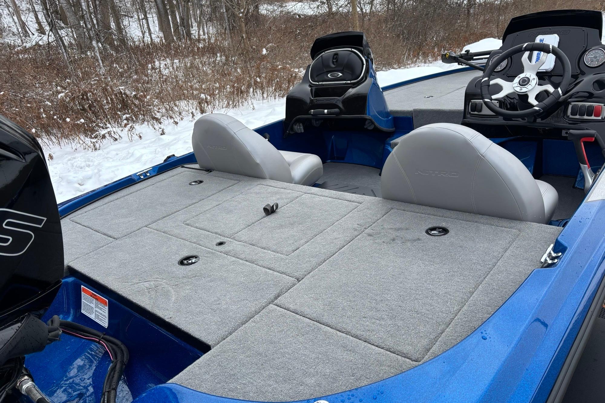 2026 Nitro Z17 boat interior with gray seating and steering wheel, snowy landscape background.