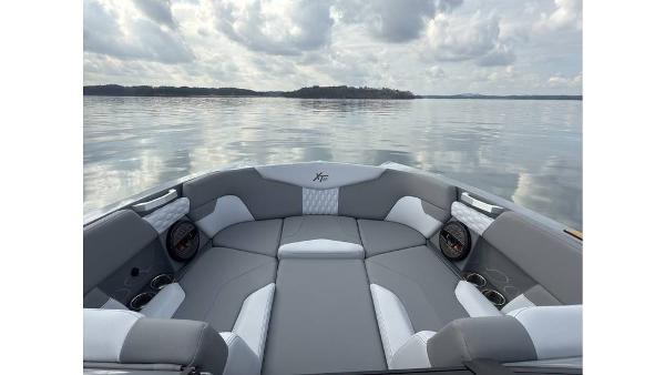 2023 MasterCraft XT22 boat interior with gray seating on a calm lake.