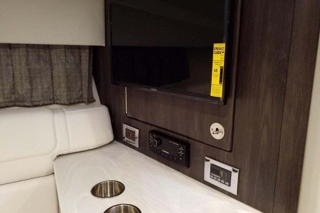 Interior of 2021 Formula 350 Sun Sport with TV, control panel, and cup holders.