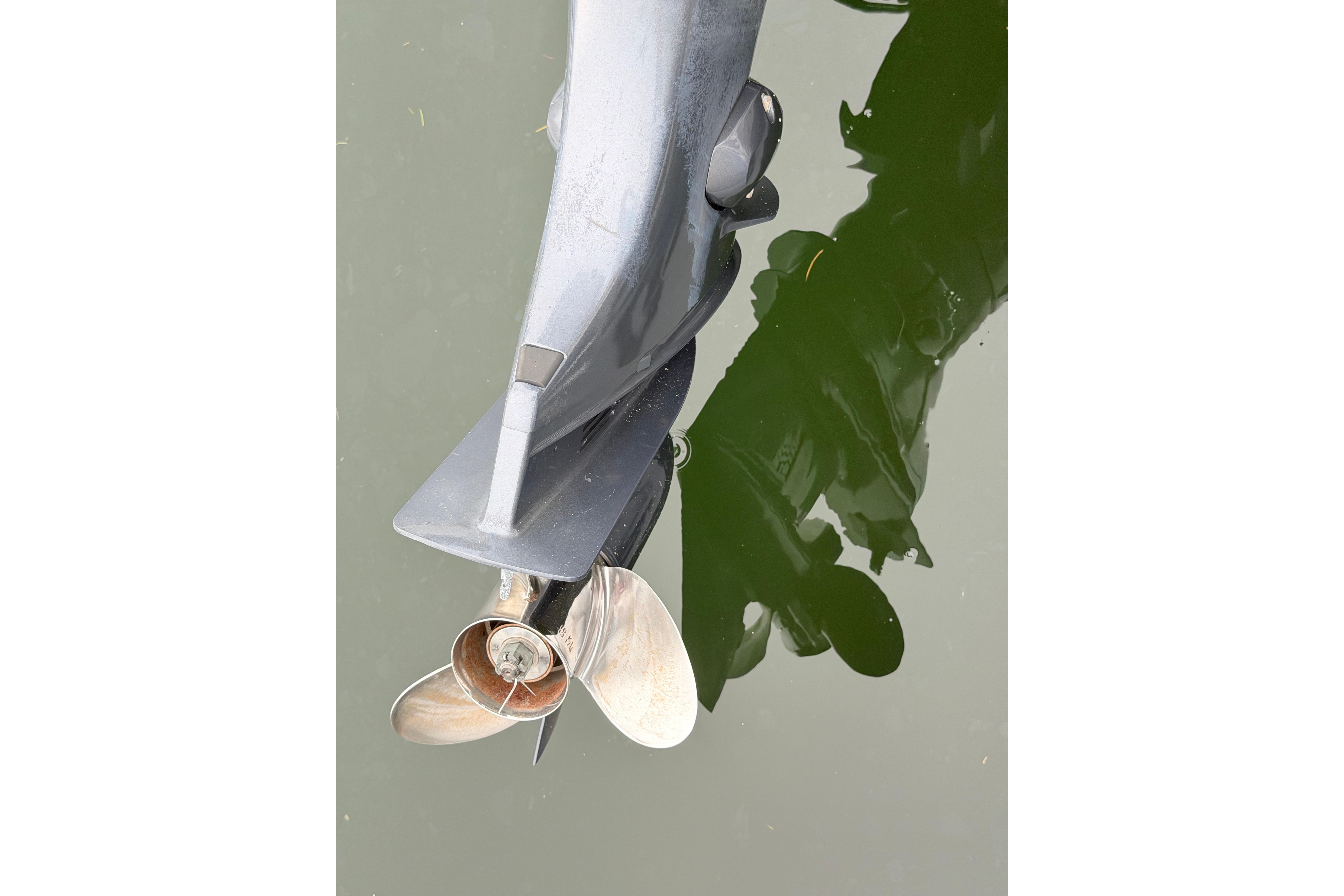 Outboard motor propeller of 2019 World Cat 230 DC reflected in water.