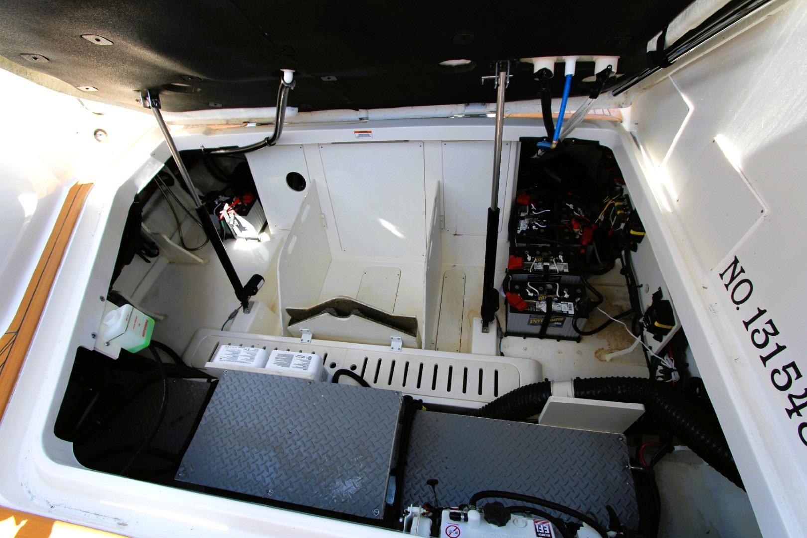 Engine compartment of 2021 Sea Ray Sundancer 320 Outboard, showcasing batteries and mechanical components.