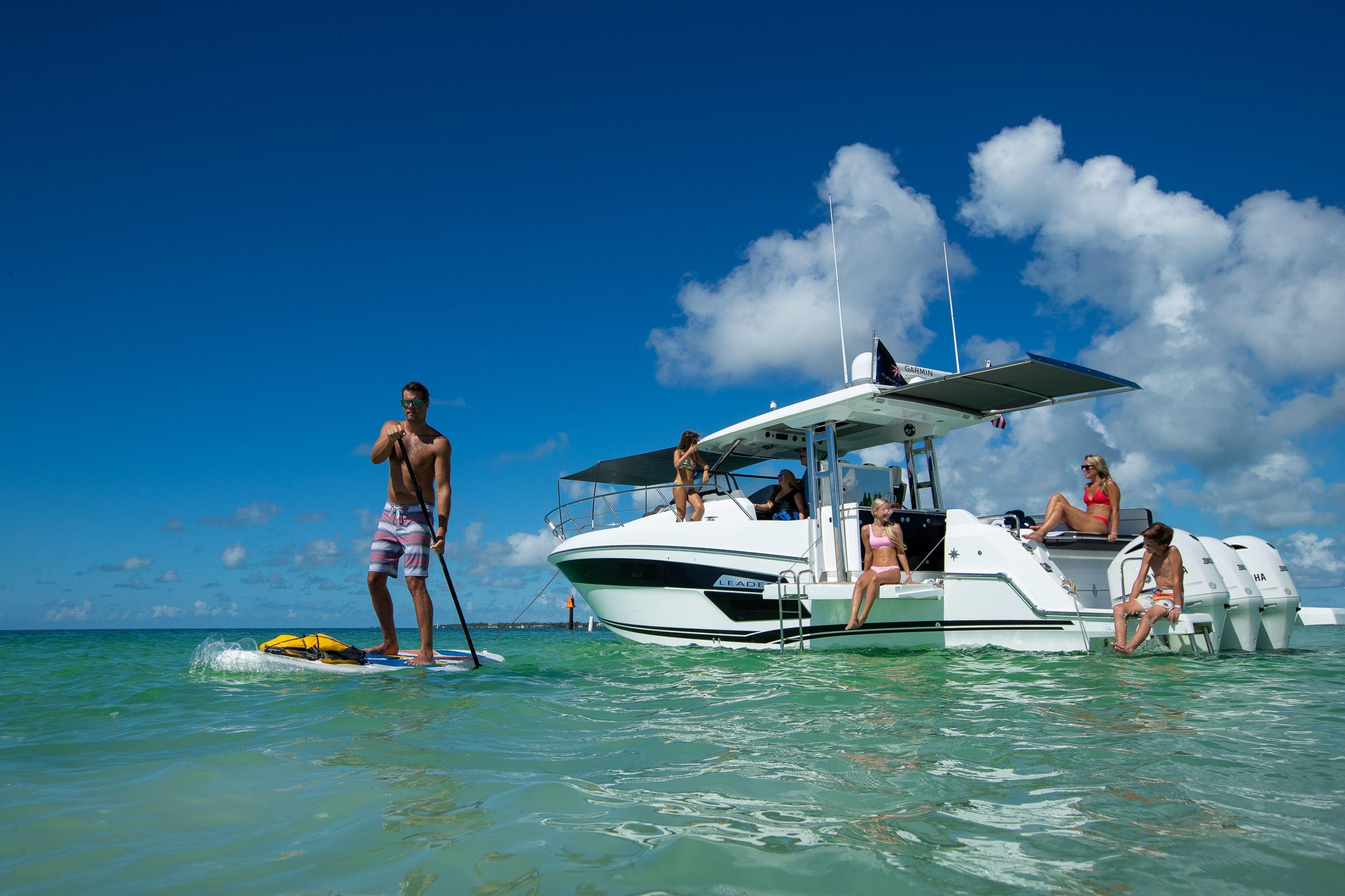 2026 Jeanneau Leader 12.5 WA yacht with people enjoying water activities.