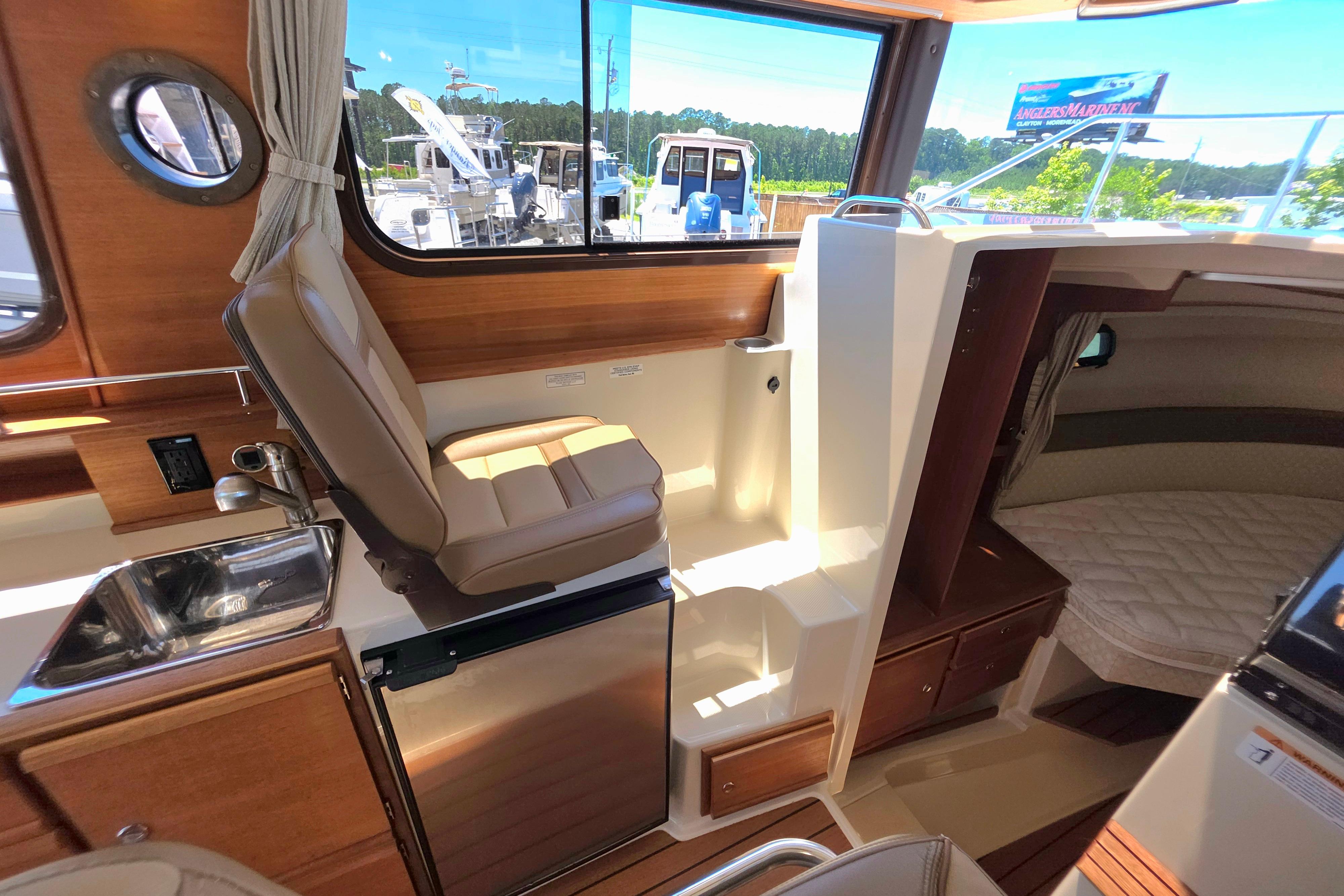 Interior of 2021 Ranger Tug R27 boat with seating, sink, and cabin area.