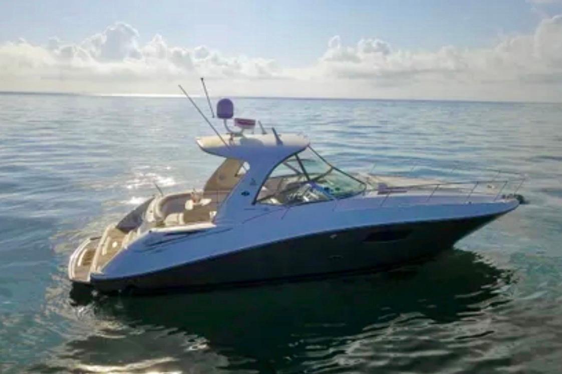 2009 Sea Ray Sundancer 350 yacht on calm ocean waters under a cloudy sky.
