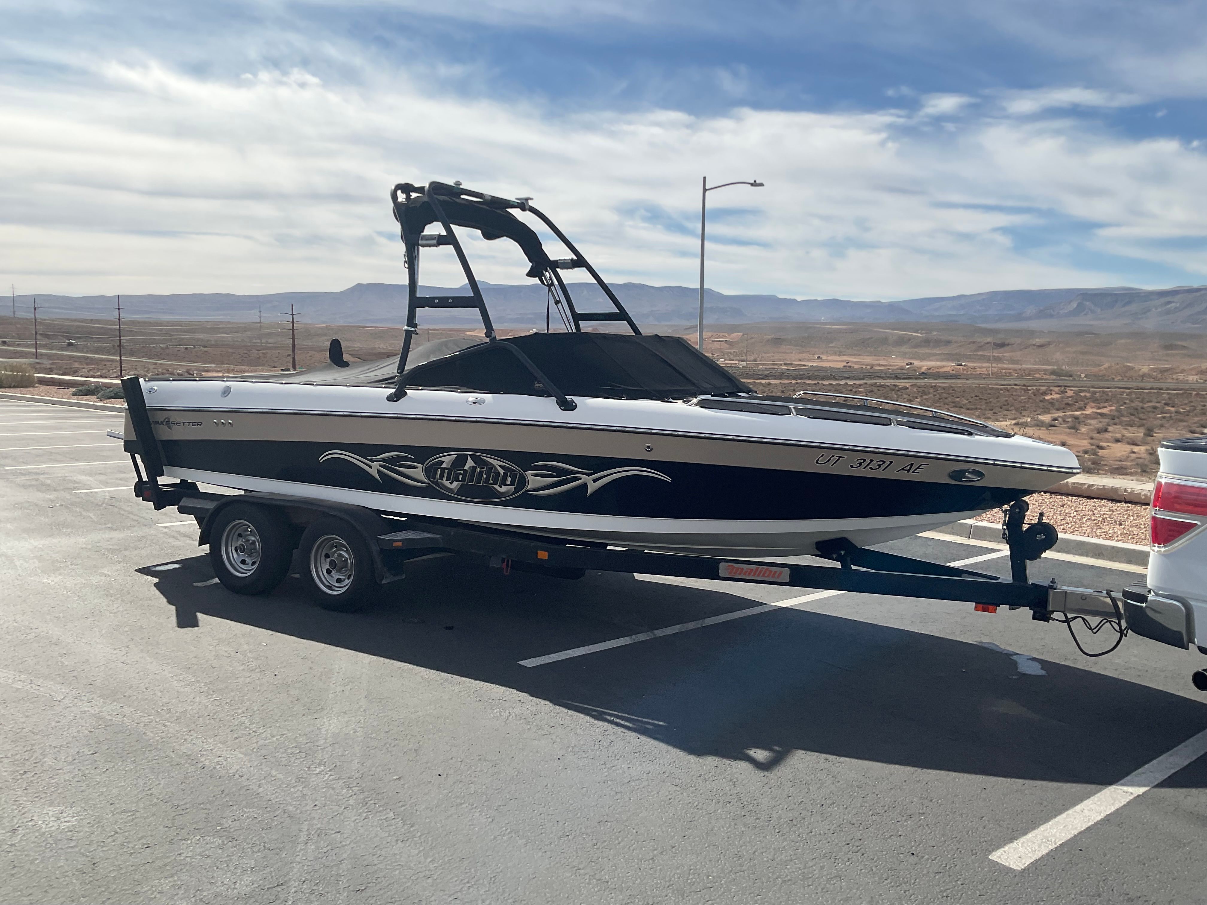 2003 Malibu Wakesetter 23 LSV on a trailer in a dry landscape.
