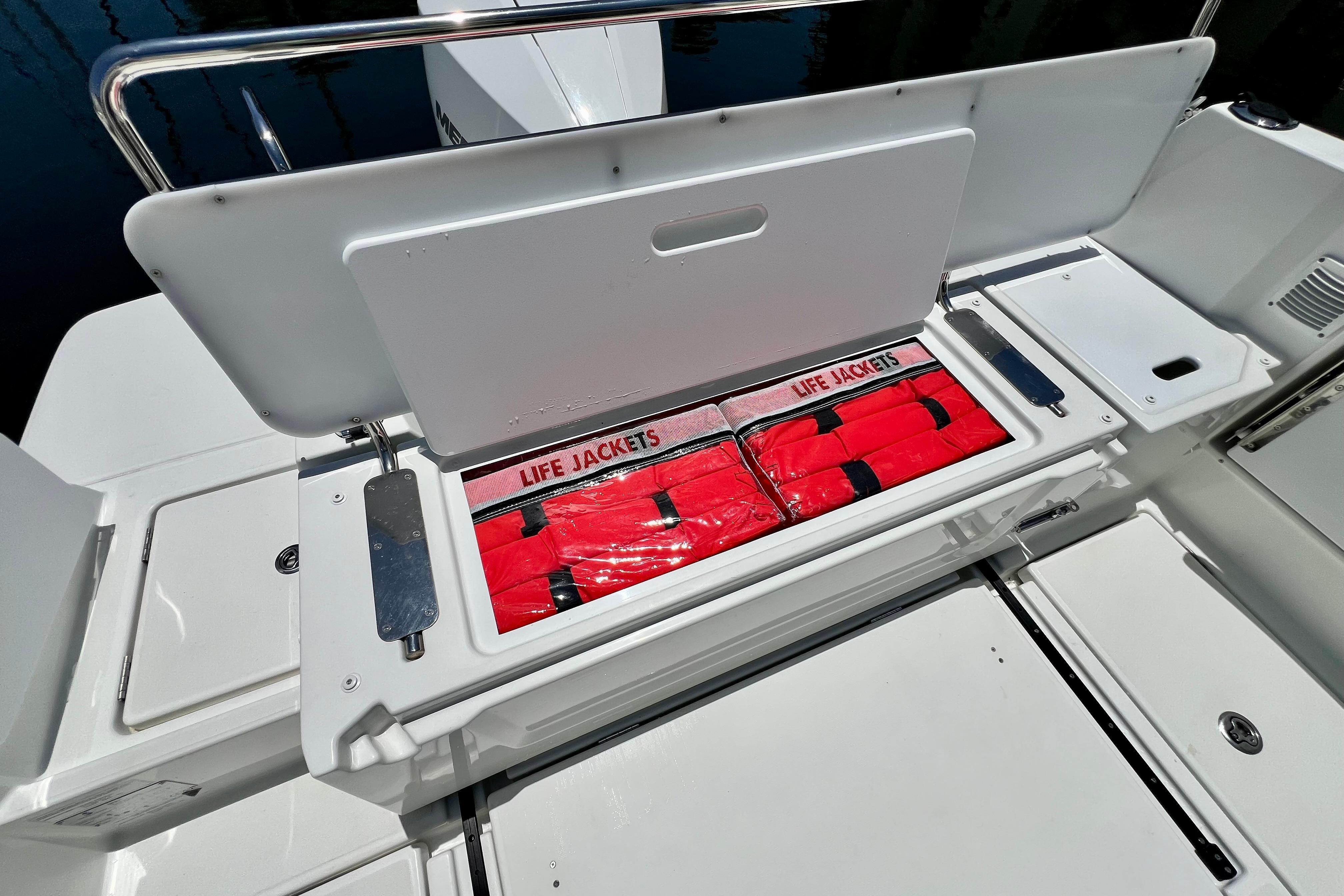 2023 Beneteau Antares 8 boat storage with red life jackets neatly organized.