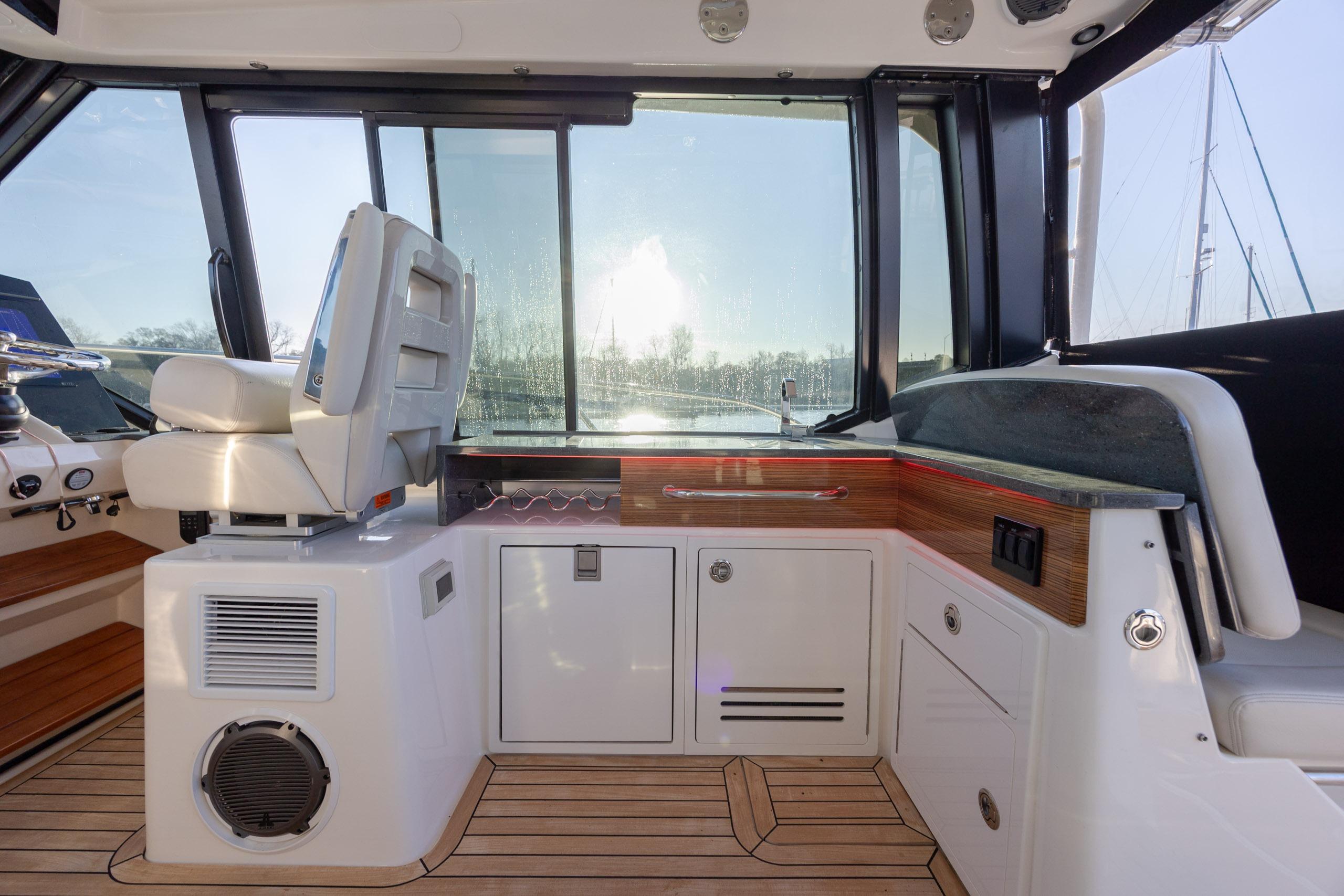 2021 Boston Whaler 405 Conquest interior with helm seat and wooden cabinetry.
