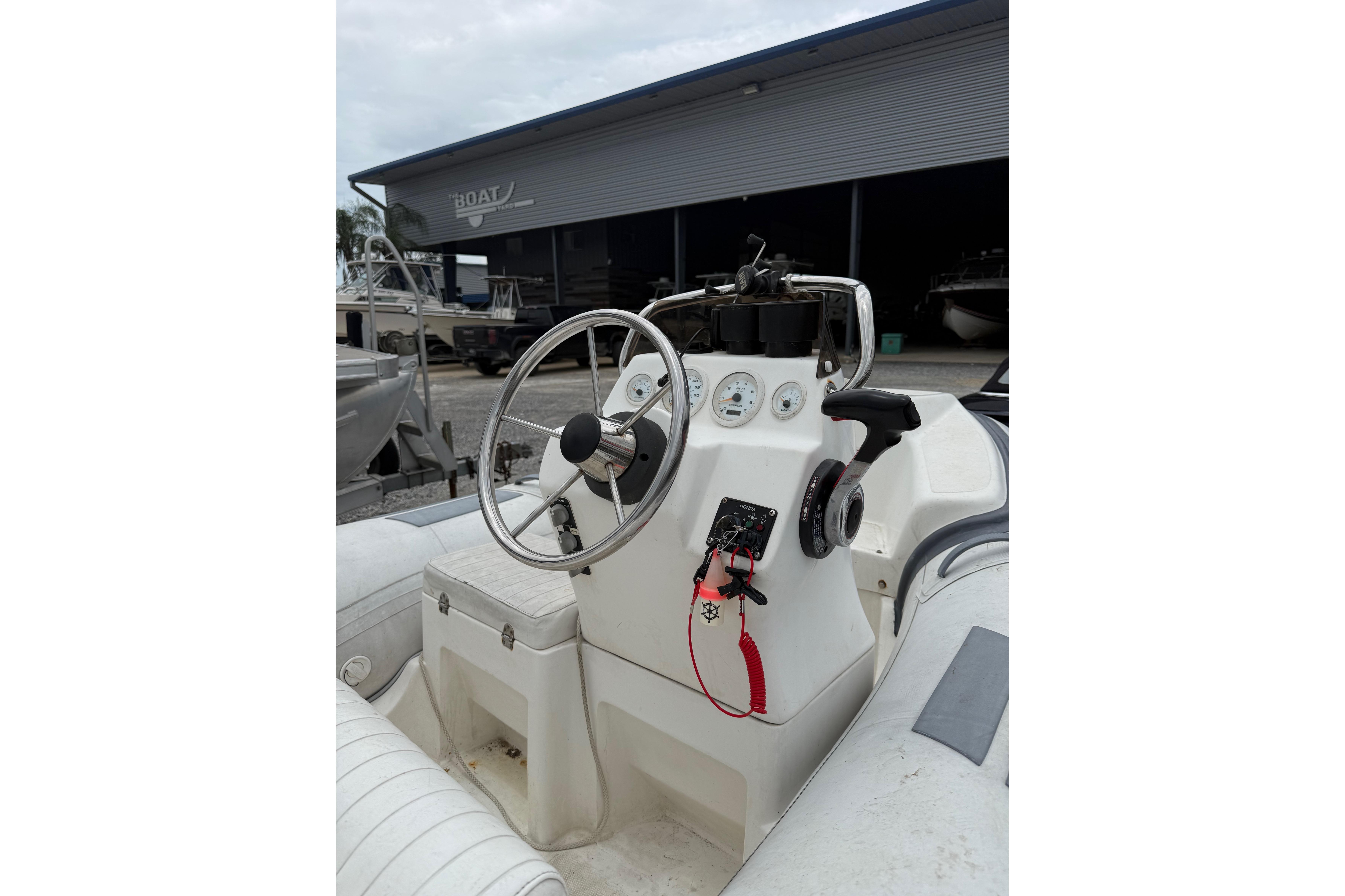 Steering console of a 2008 Caribe DL-11 boat, featuring gauges and controls.