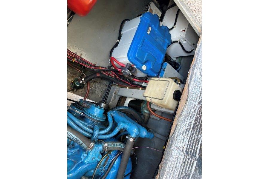 Engine compartment of 1987 Tollycraft 34 Sundeck Motor Yacht, featuring blue components and wiring.