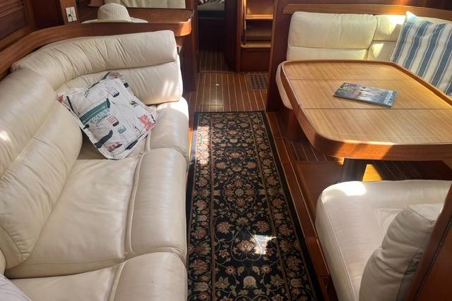 Luxurious interior of 2002 Sabre 452 yacht with leather seating and wooden table.
