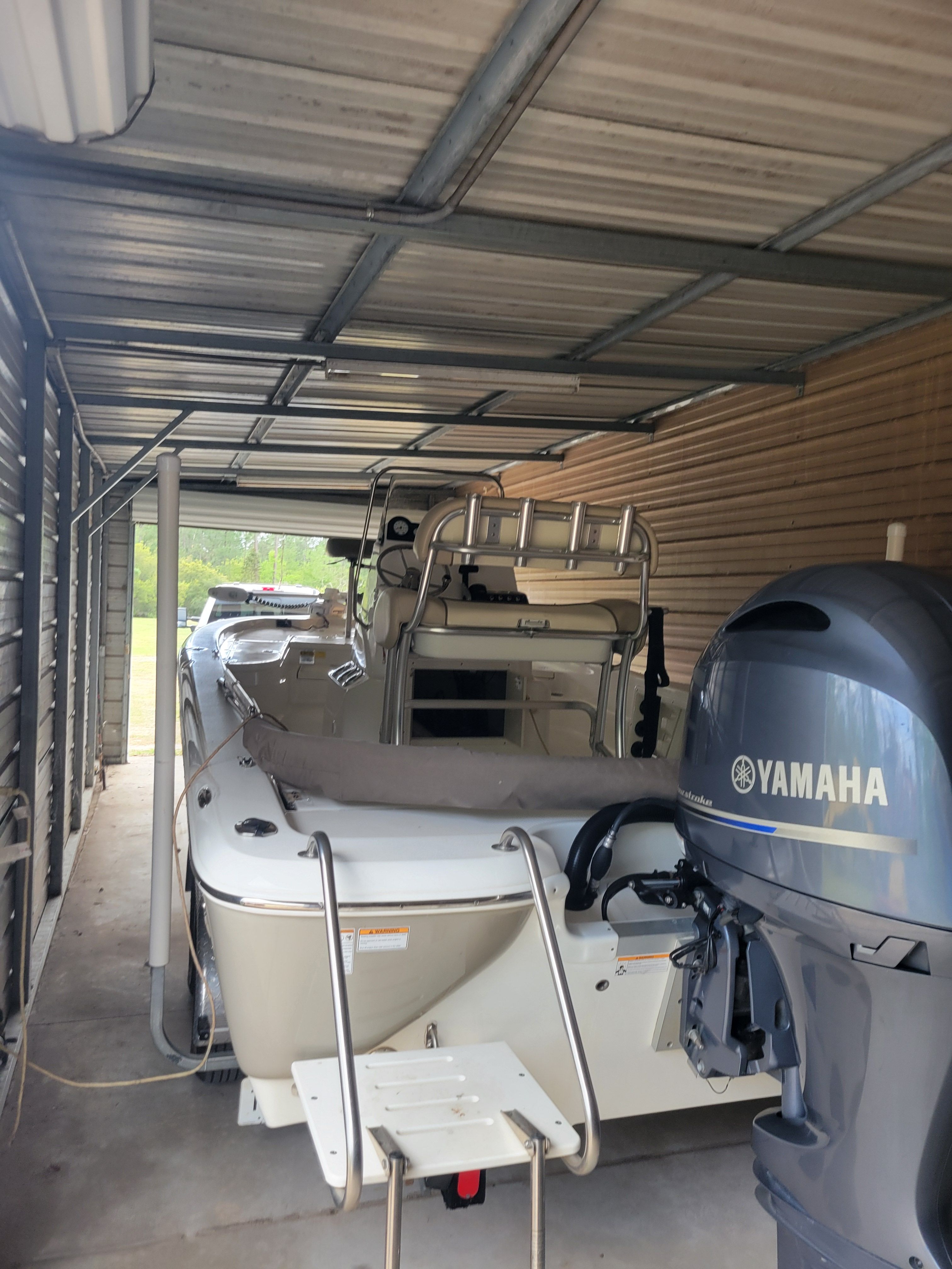 A 2017 NauticStar 2200 Sport boat is parked in a covered area.