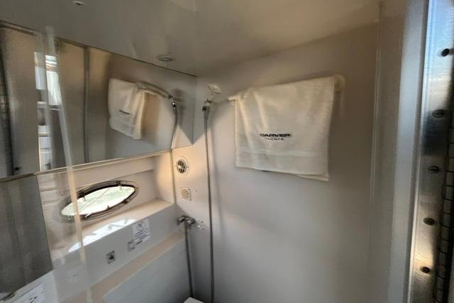 Bathroom interior of 1995 Carver 325 Aft Cabin Motor Yacht with towel and shower.