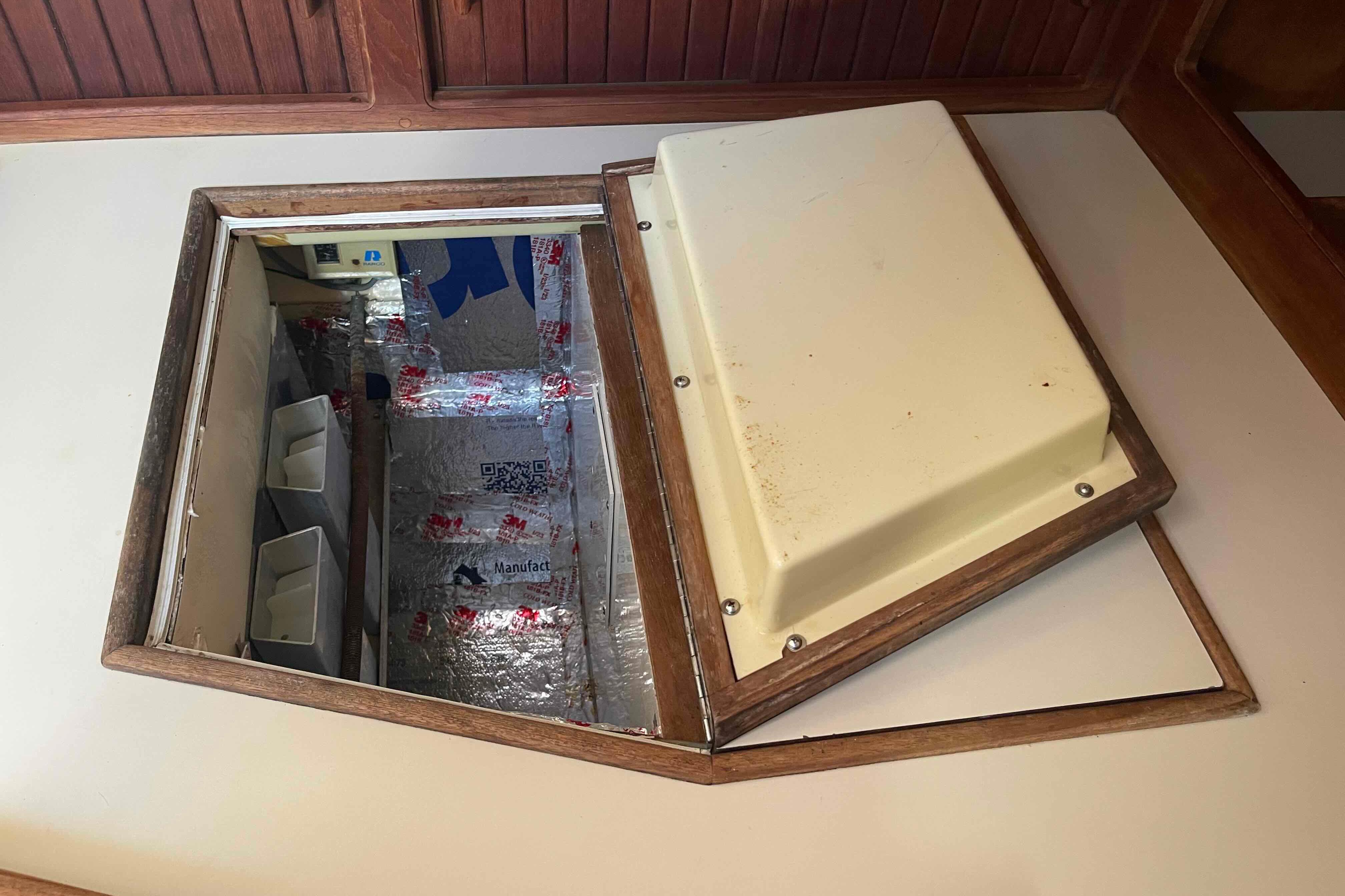 Hatch opening on 1989 Island Packet 35 sailboat, revealing insulated compartment.