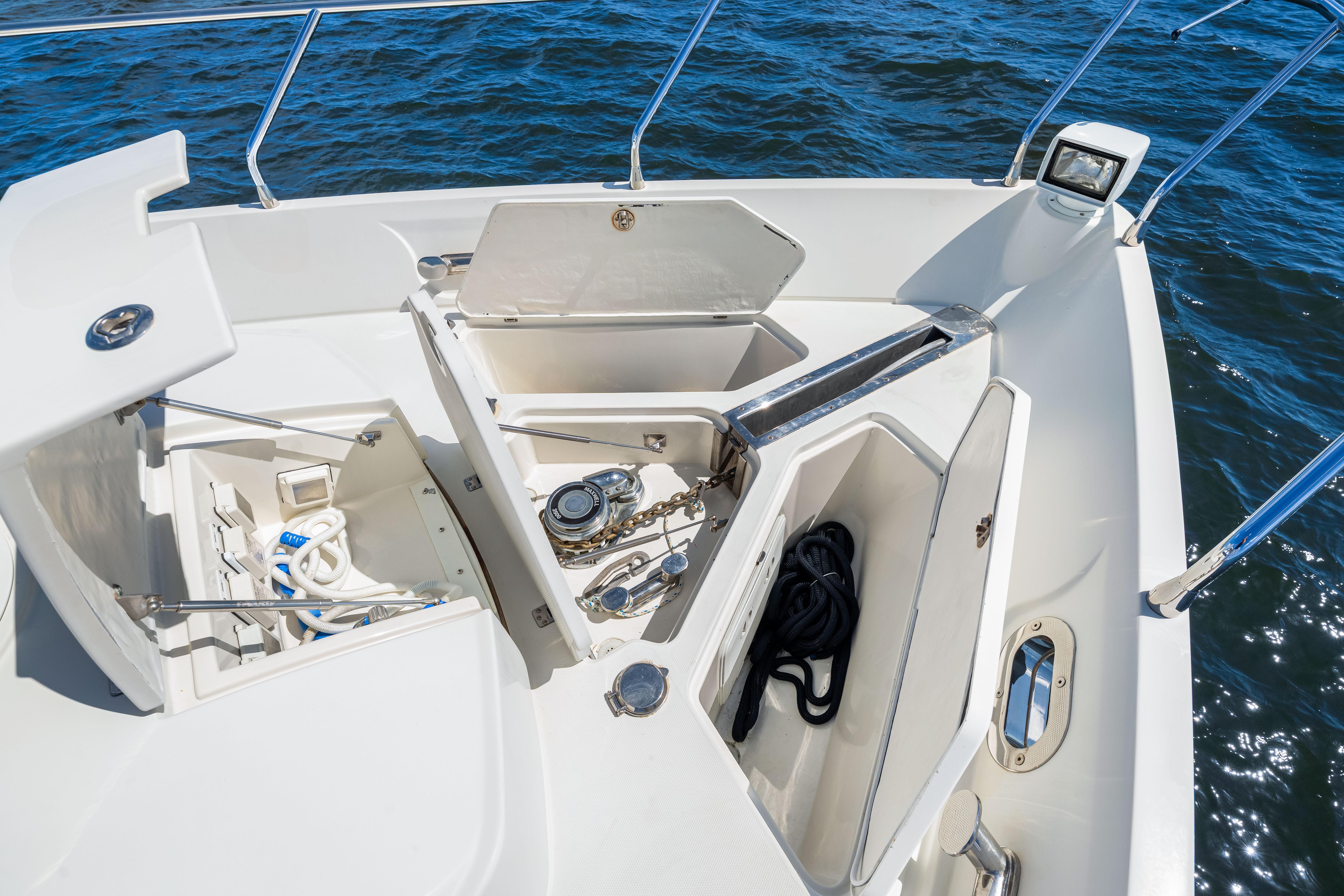 Open storage compartments on 2007 Marquis 59 Markham Edition yacht deck, with ropes and equipment.