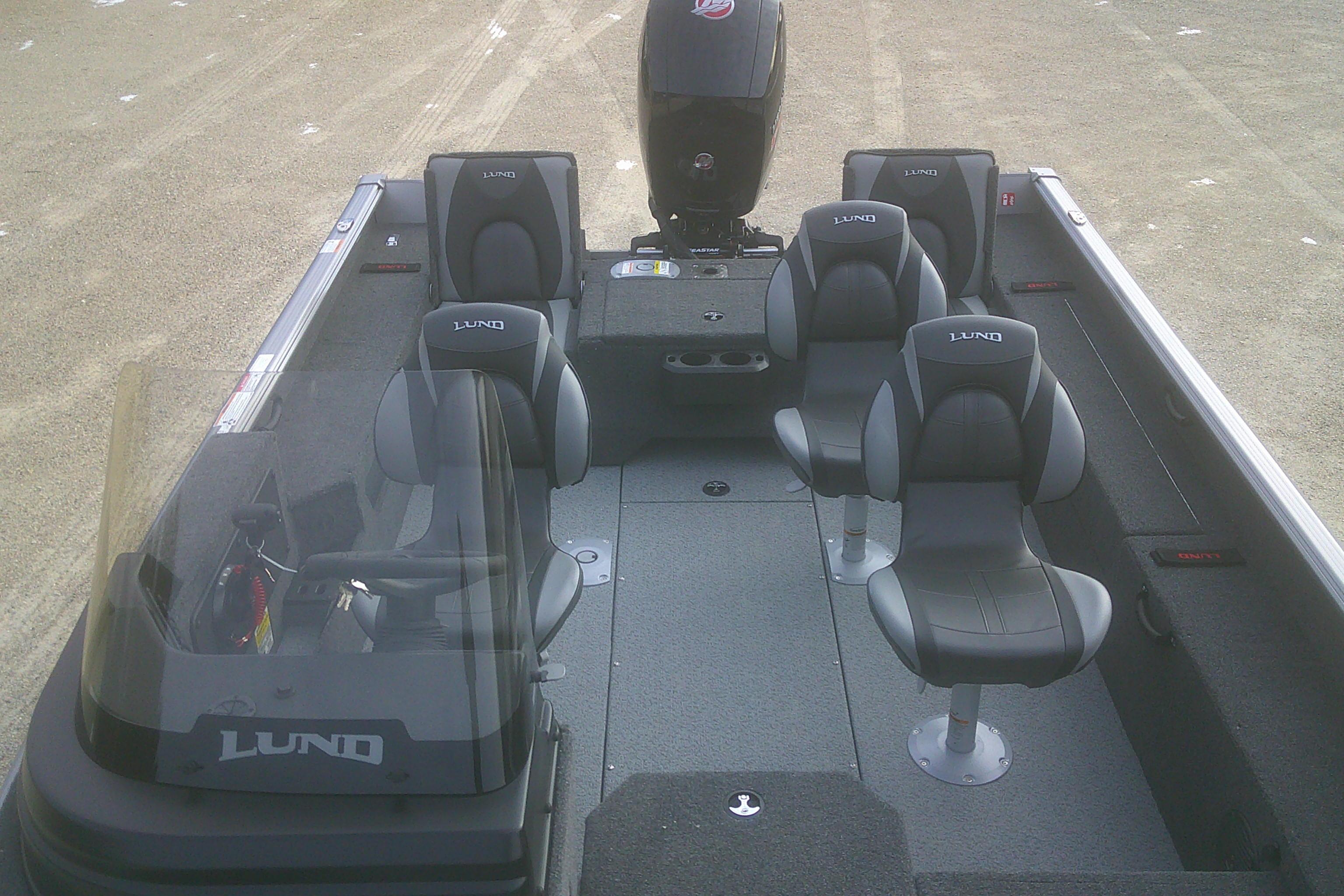 2026 Lund 1875 Impact XS SS boat interior with four seats and motor, designed for fishing.