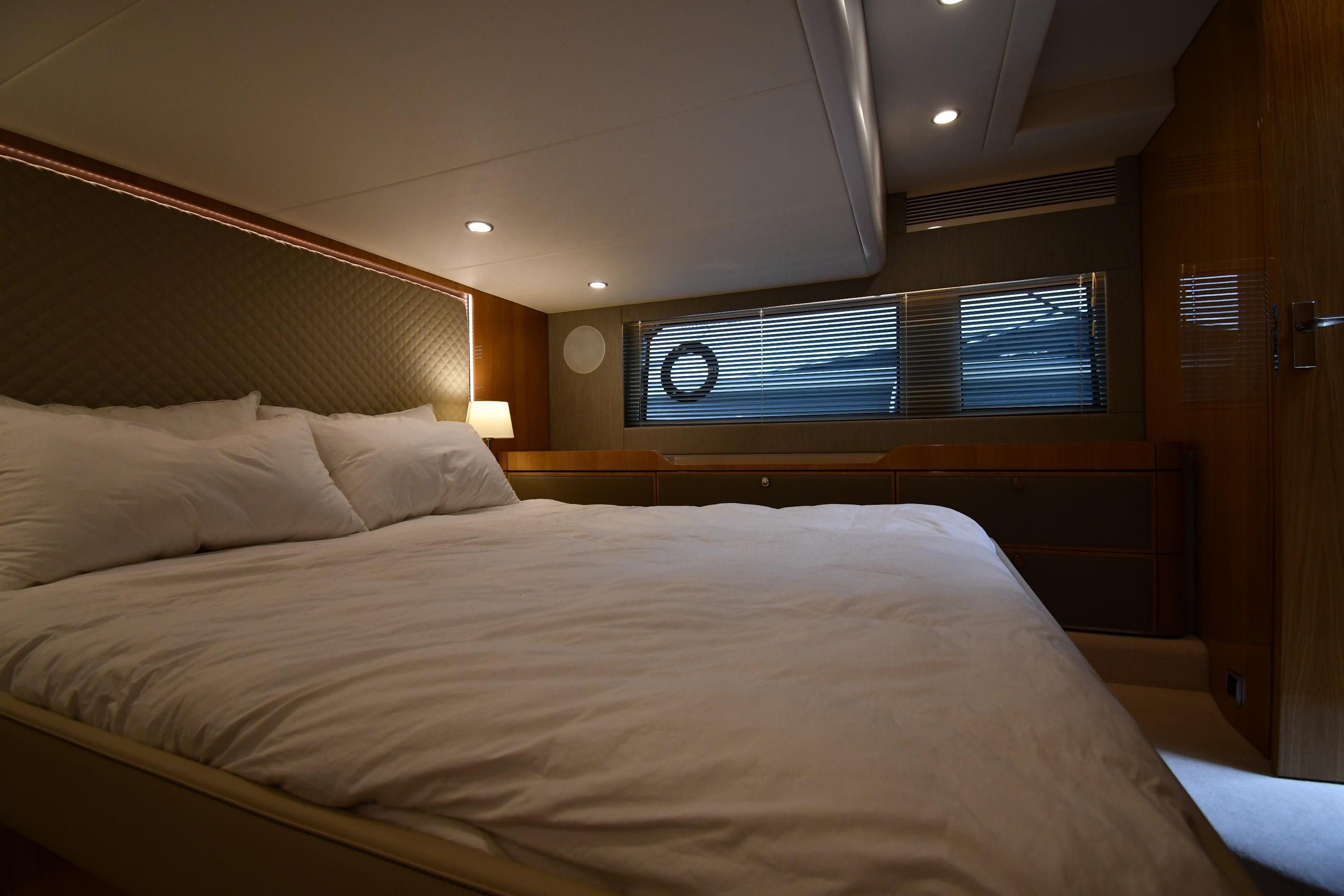 Luxurious bedroom interior of 2024 Fairline G50 Targa yacht with modern lighting and cozy bedding.