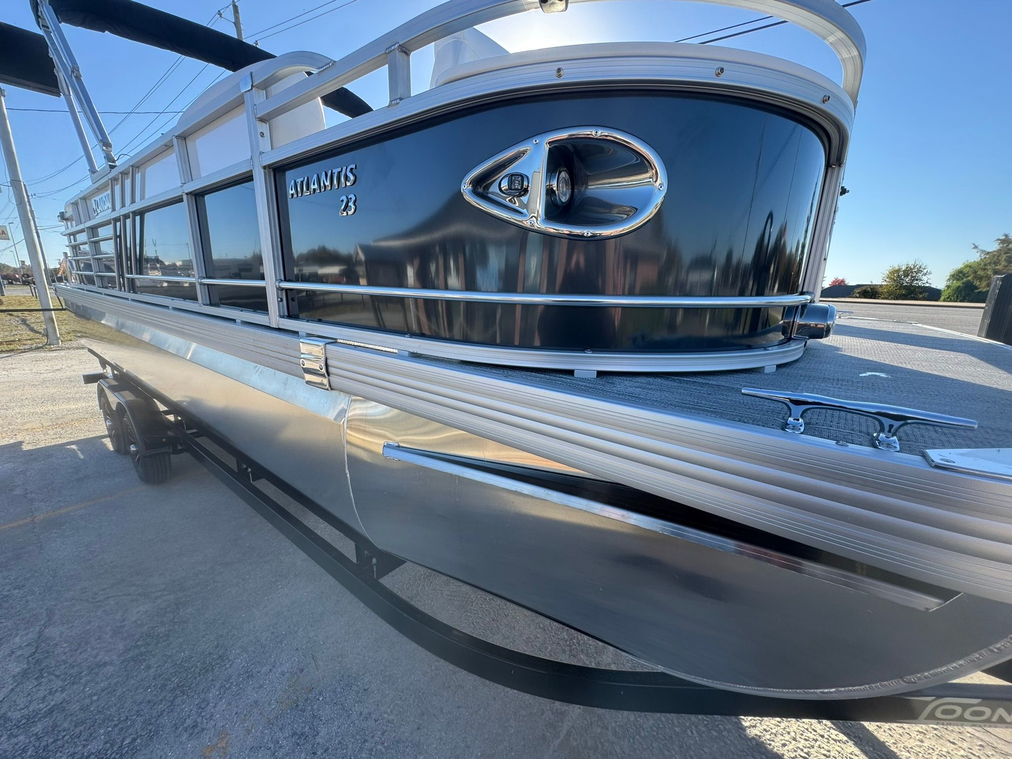 Landau 23C Atlantis 2026 pontoon boat on trailer, shiny black finish.
