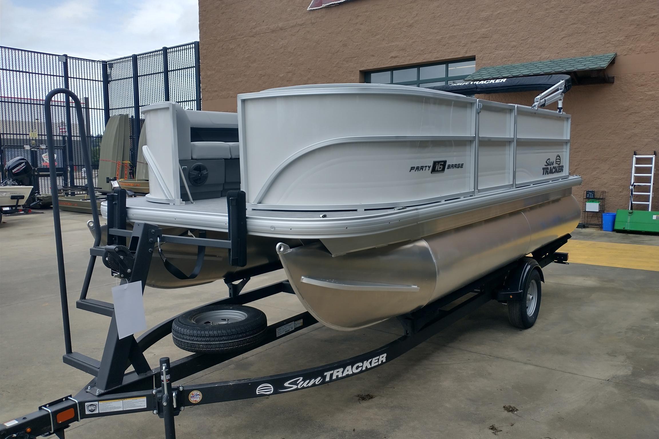 2026 Sun Tracker Party Barge 16 DLX pontoon boat on trailer, outdoor display.
